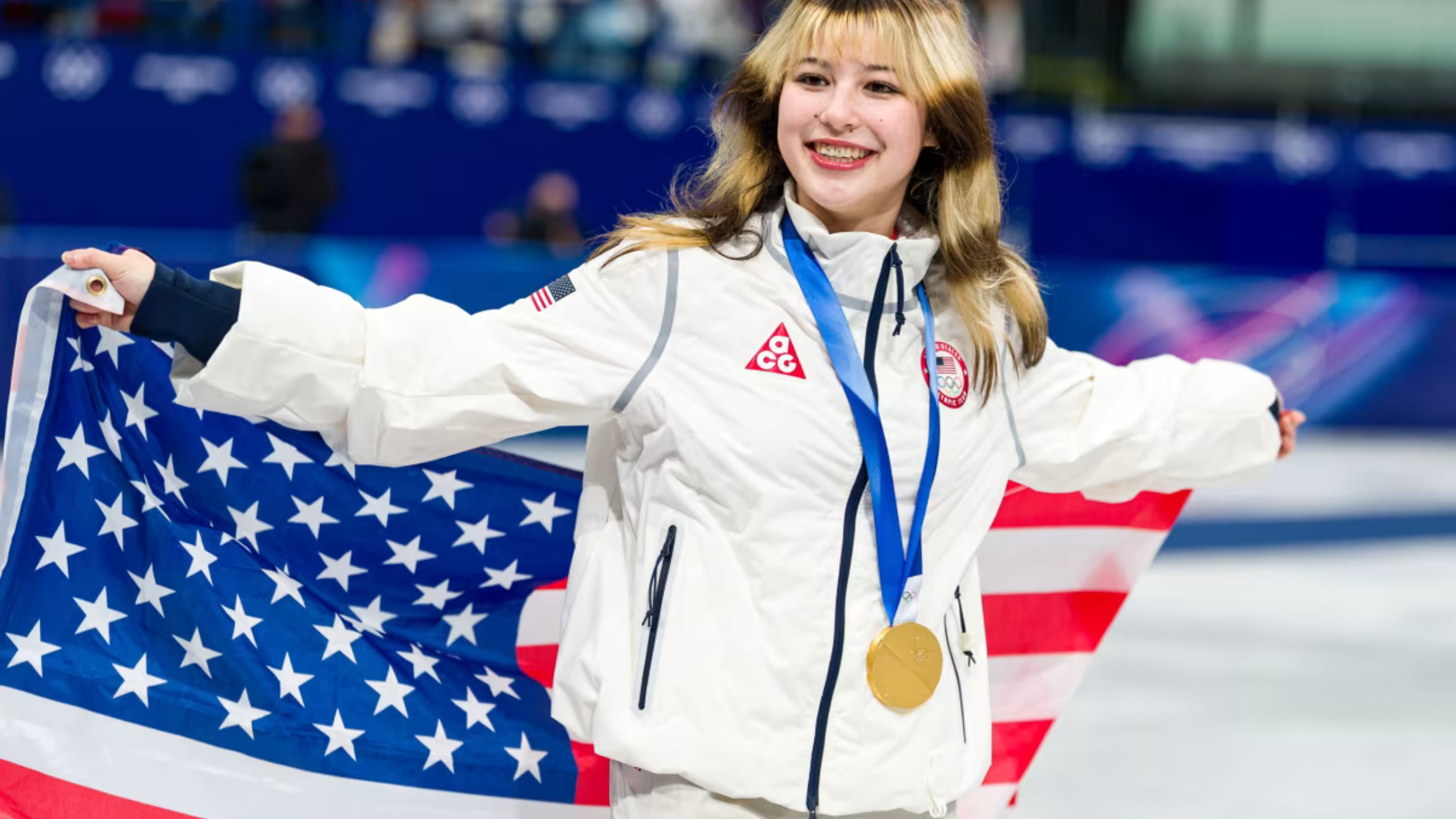 Alyssa Liu celebrates in Team USA Milano 2026 Winter Olympics white arena jacket with red and navy accents and Olympic emblem