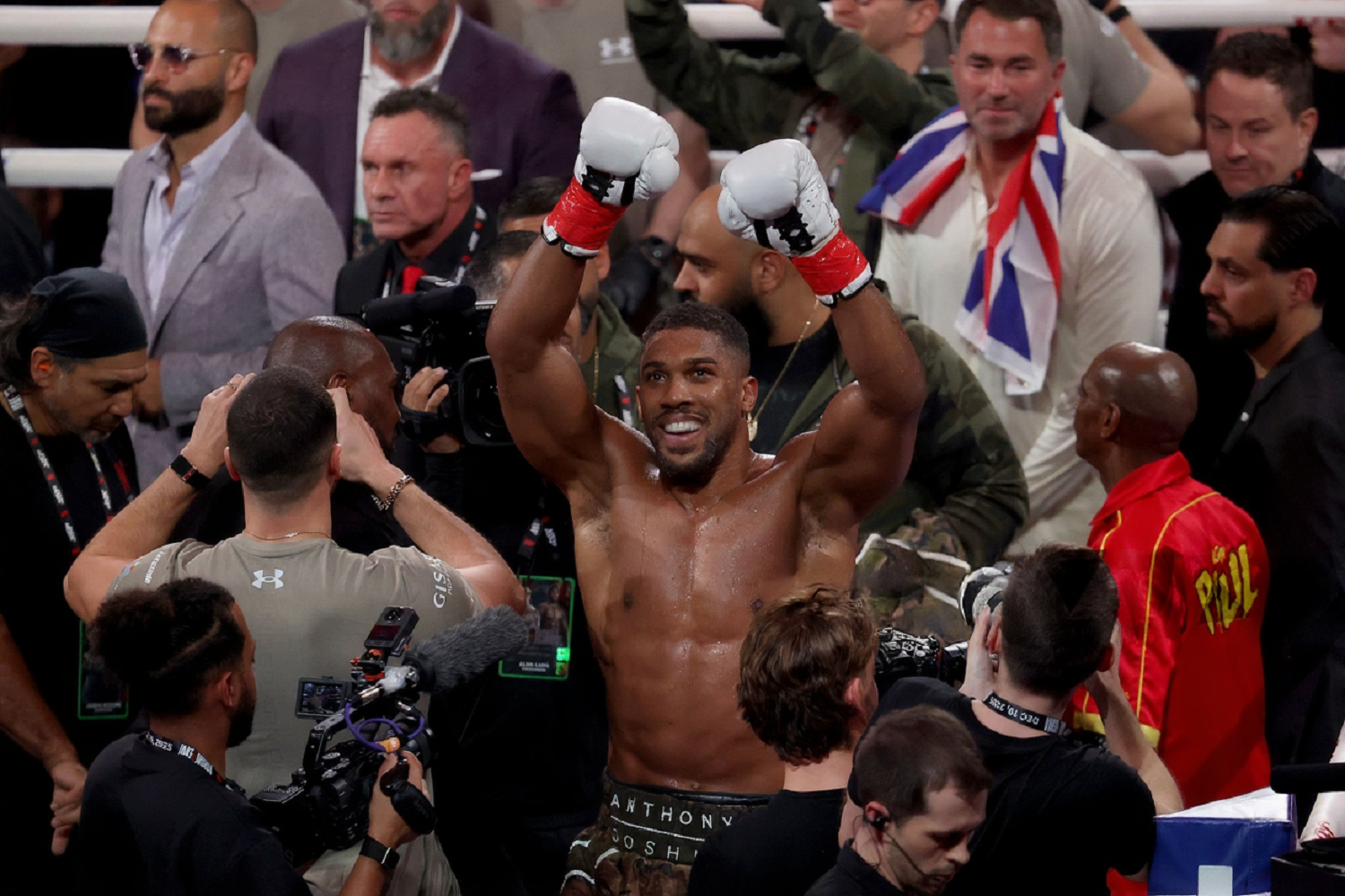 Jake Paul wearing a red Hulkamania-inspired boxing walkout jacket with yellow flames and sunglasses at his fight against Anthony Joshua