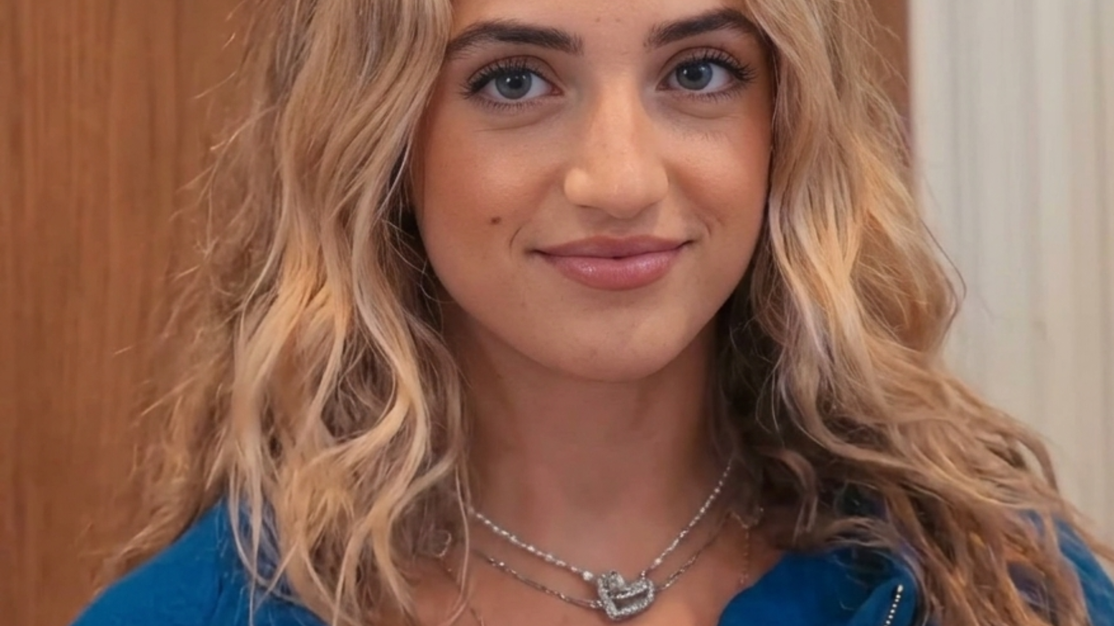 Princess Andre wearing a royal blue cropped zip hoodie with DÈS VU logo and oversized streetwear fit in The Princess Diaries episode 1×01.