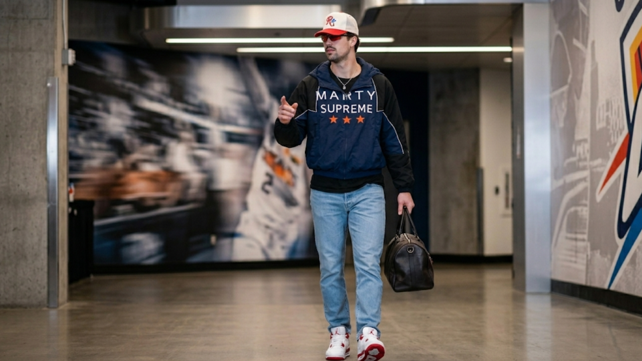 Deni Avdija Spurs vs Trail Blazers 2026 Marty Supreme jacket with navy black color-block design, white piping, and orange star graphics