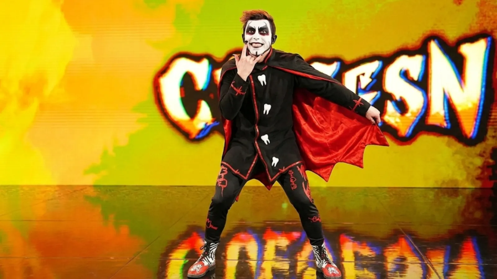 Danhausen Monday Night RAW 2026 black batwing cape tunic shirt with red piping asymmetrical hem and tooth graphic design