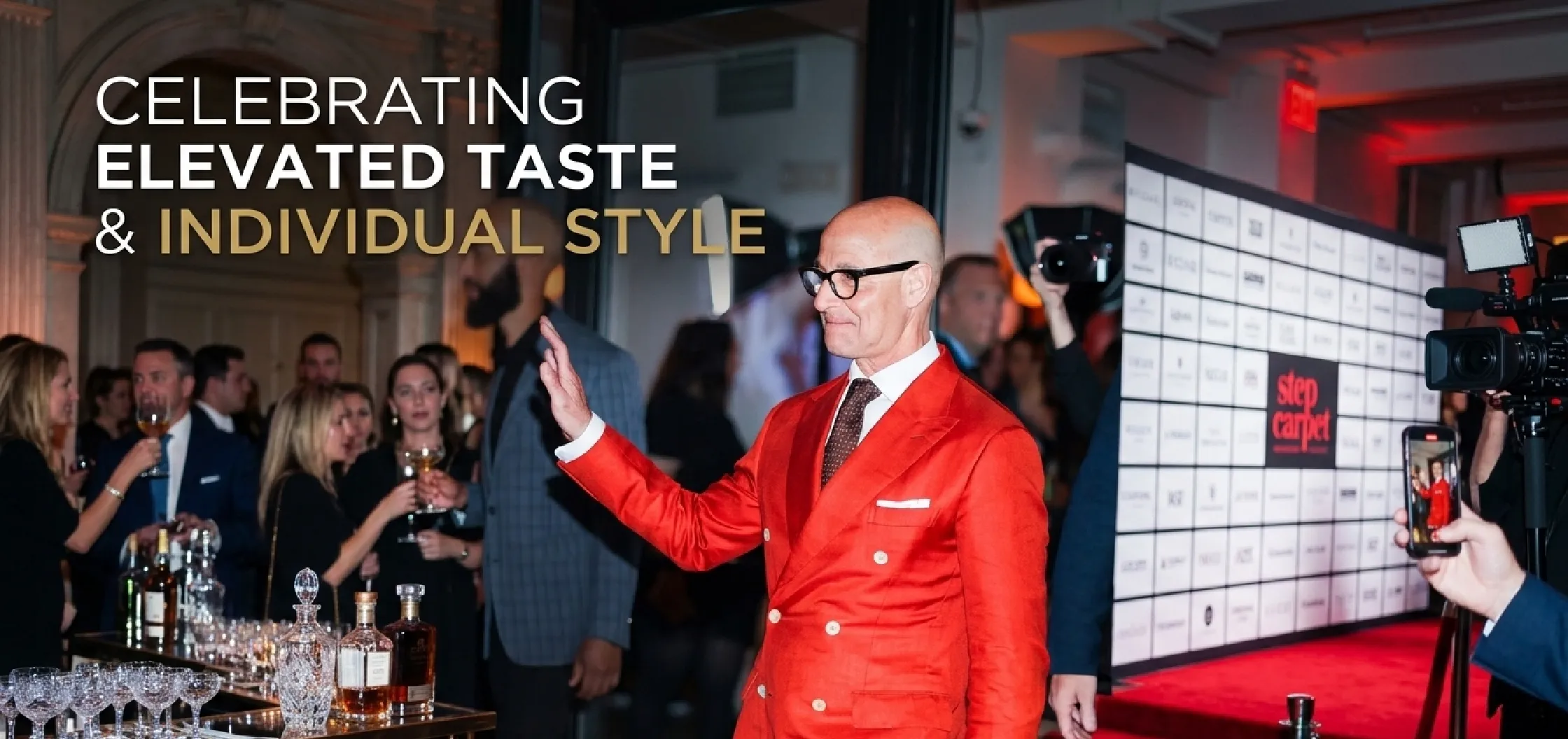 Stanley Tucci wearing a red double-breasted linen blazer with peak lapels at The Devil Wears Prada 2 NYC screening 2026