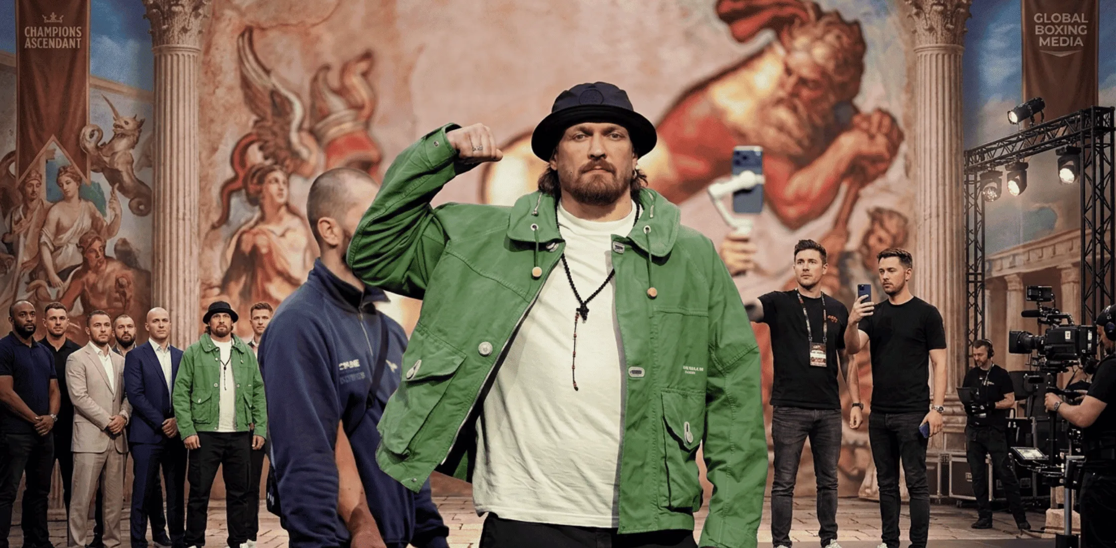 Oleksandr Usyk Glory In Giza Launch Press Conference sage-green utility field jacket with drawstring hood, wooden toggle details, and oversized flap pockets in modern structured fit.