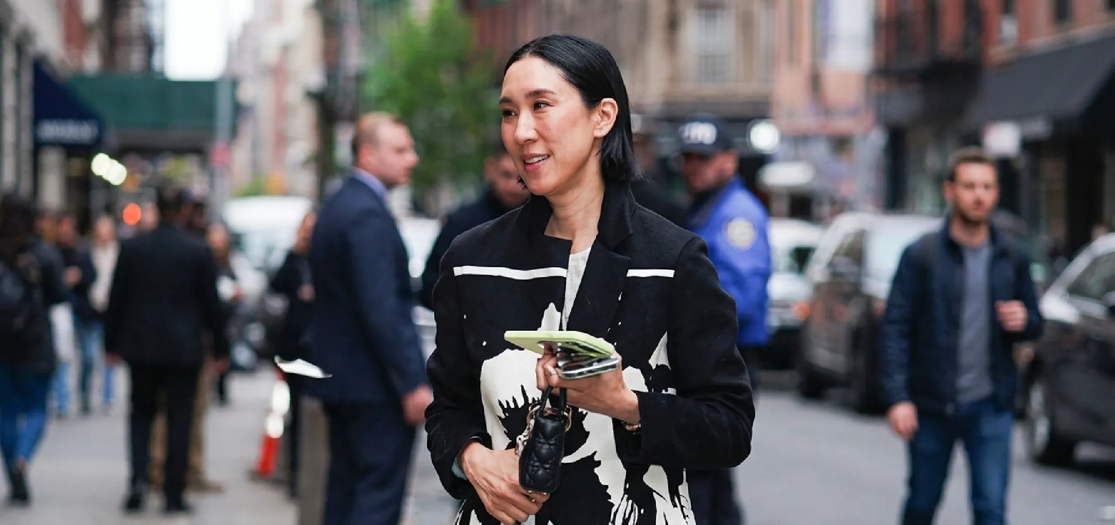 Eva Chen wearing a black and white abstract floral print longline trench coat at The Devil Wears Prada 2 NYC 2026 screening