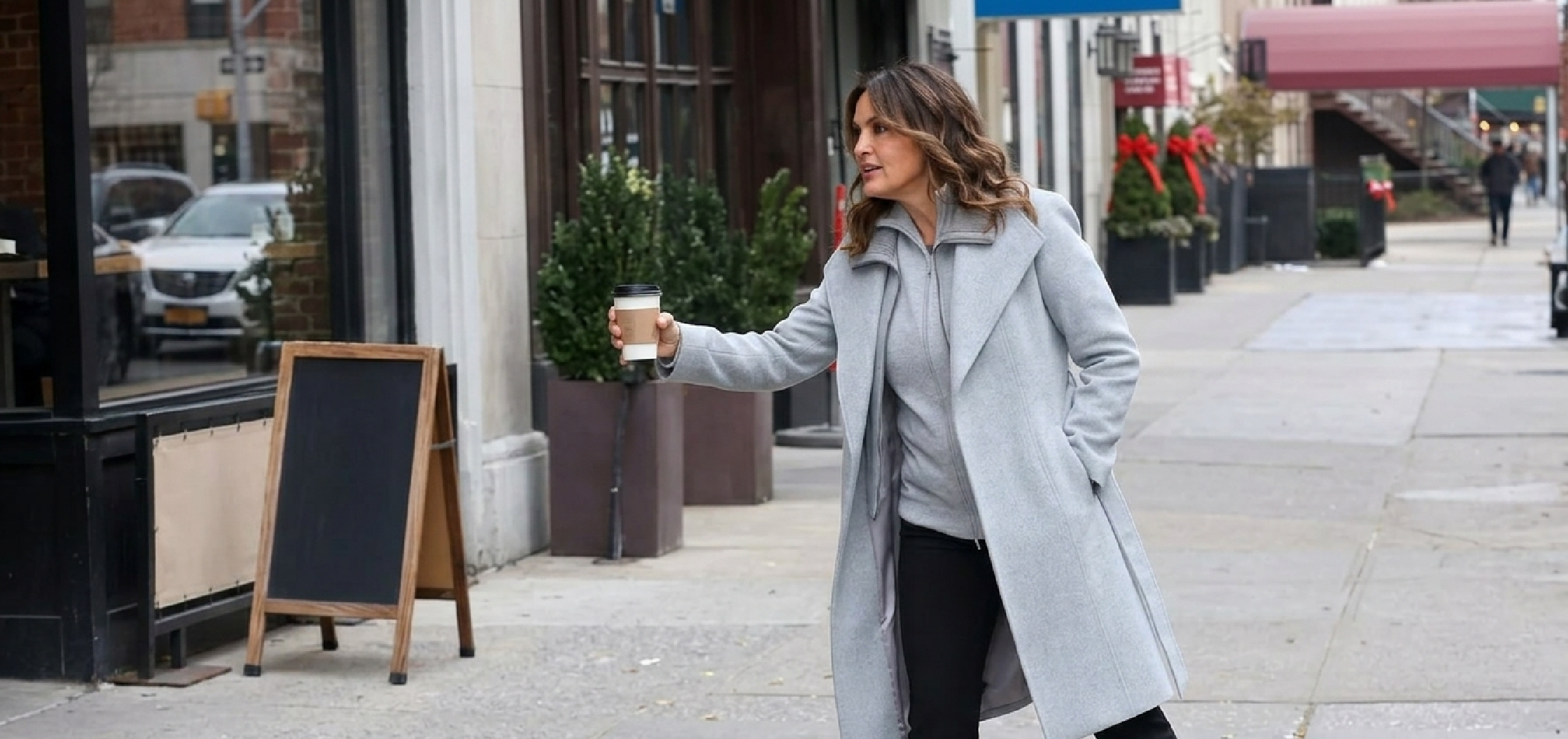 Mariska Hargitay wearing a light gray wool wrap coat with shawl lapels and belted waist in Law & Order: SVU 2025 filming scene