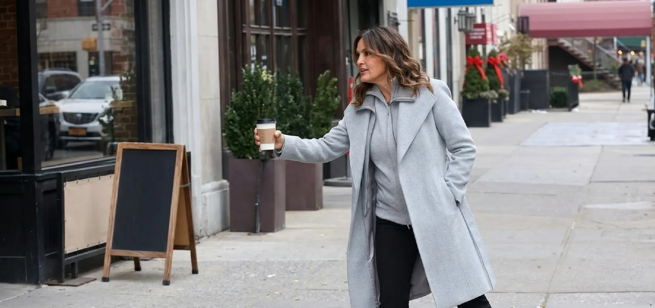 Mariska Hargitay wearing a light gray wool wrap coat with shawl lapels and belted waist in Law & Order: SVU 2025 filming scene