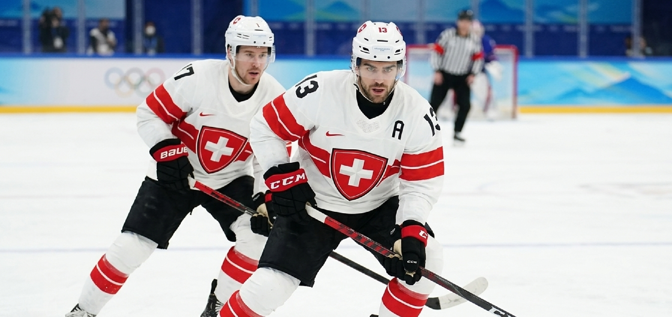 Milano Cortina 2026 Winter Olympics Team Switzerland ice hockey jersey featuring white base, bold red chest stripe, Swiss cross crest, black alternate captain “A”, and performance mesh fabric design.