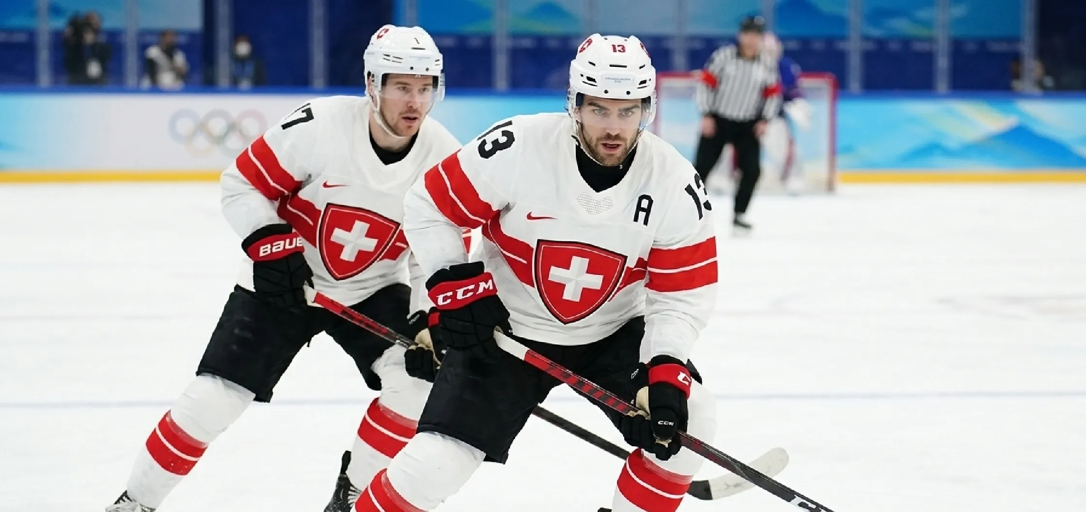 Milano Cortina 2026 Winter Olympics Team Switzerland ice hockey jersey featuring white base, bold red chest stripe, Swiss cross crest, black alternate captain “A”, and performance mesh fabric design.