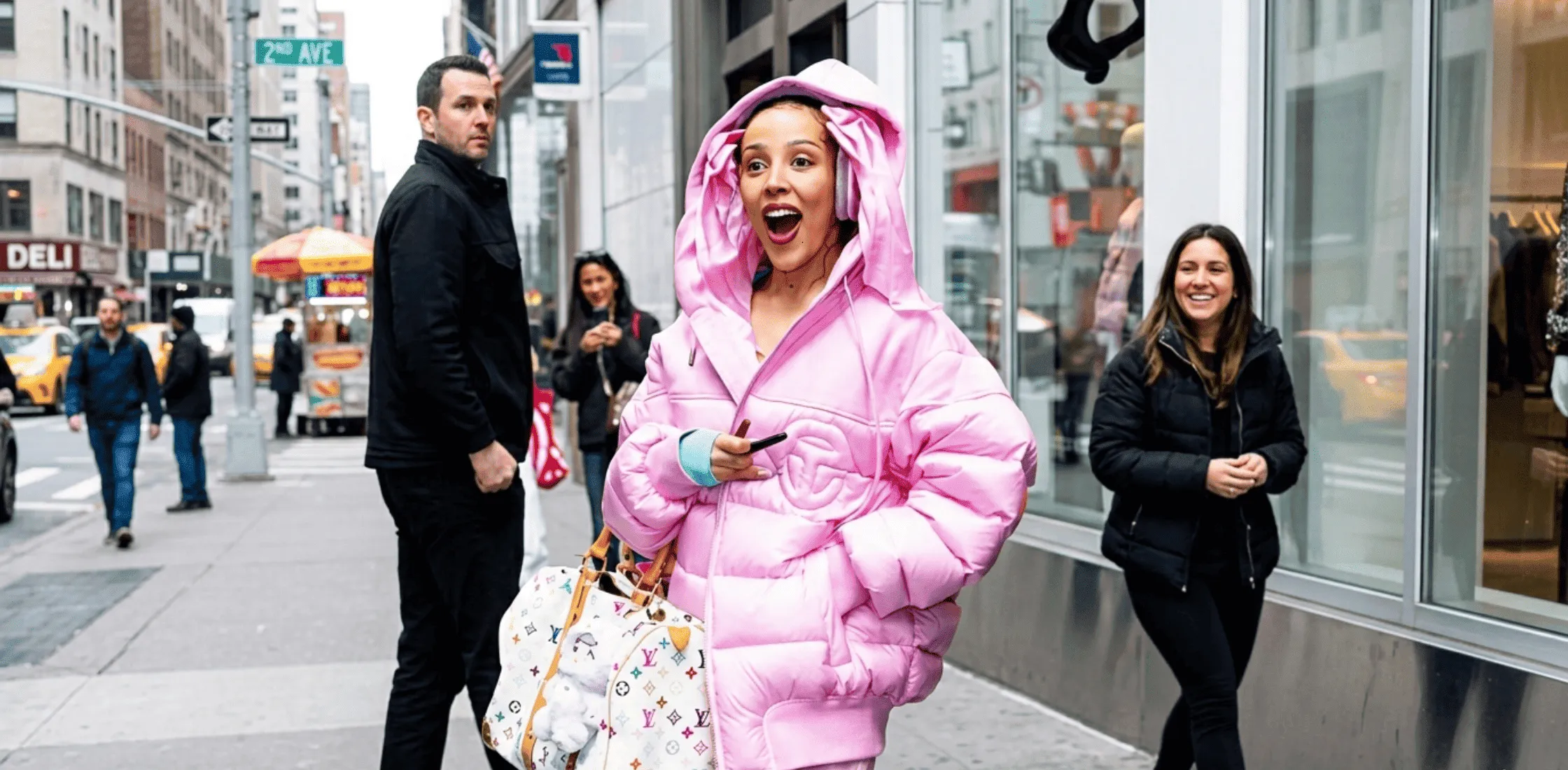 Doja Cat wearing a pink oversized Telfar puffer jacket with matching pants and Louis Vuitton x Takashi Murakami duffle bag in New York City before the Met Gala 2026