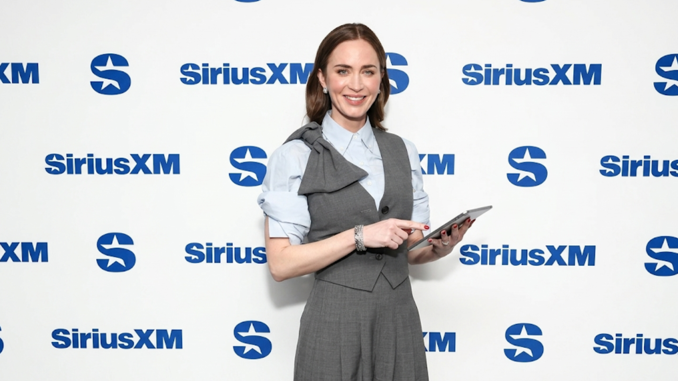 Emily Blunt The Devil Wears Prada 2 grey tailored waistcoat with asymmetrical sculptural shoulder bow detail and deep V-neck design