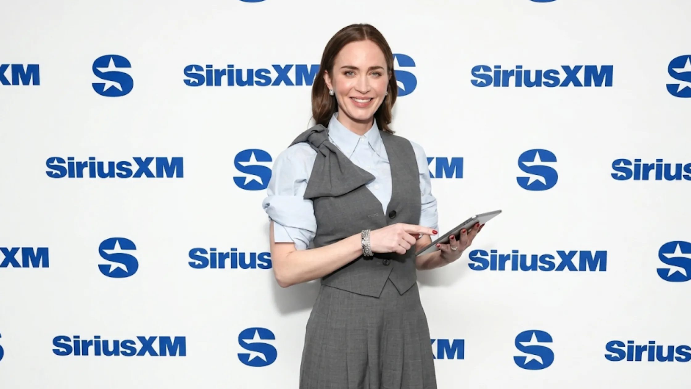 Emily Blunt The Devil Wears Prada 2 grey tailored waistcoat with asymmetrical sculptural shoulder bow detail and deep V-neck design