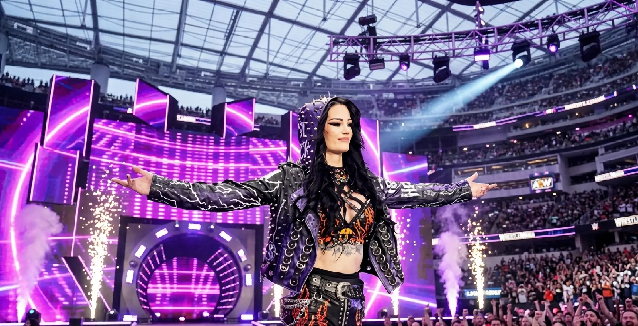 Saraya Jade Bevis (Paige) wearing a black gothic punk hooded leather jacket with spikes and a studded “P” emblem during WrestleMania 2026 return