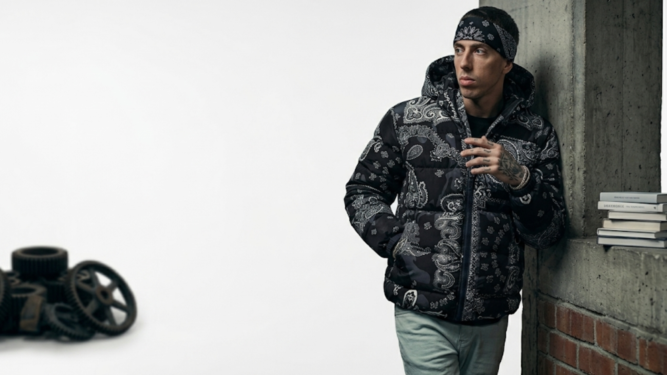 Central Cee black hooded bomber jacket with paisley print, acid wash texture, ARTKRAFT gothic chest logo, and oversized streetwear fit