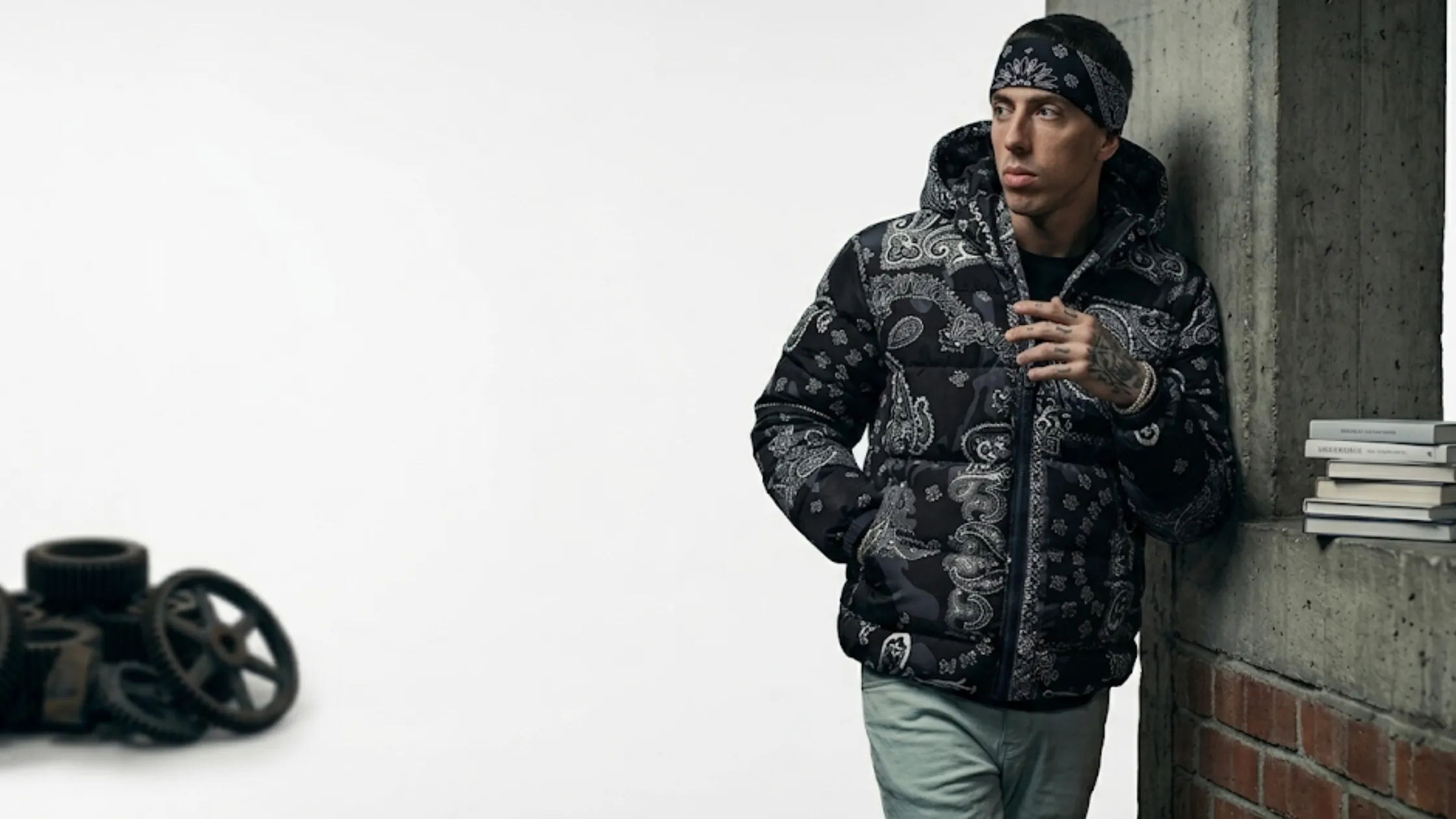 Central Cee black hooded bomber jacket with paisley print, acid wash texture, ARTKRAFT gothic chest logo, and oversized streetwear fit