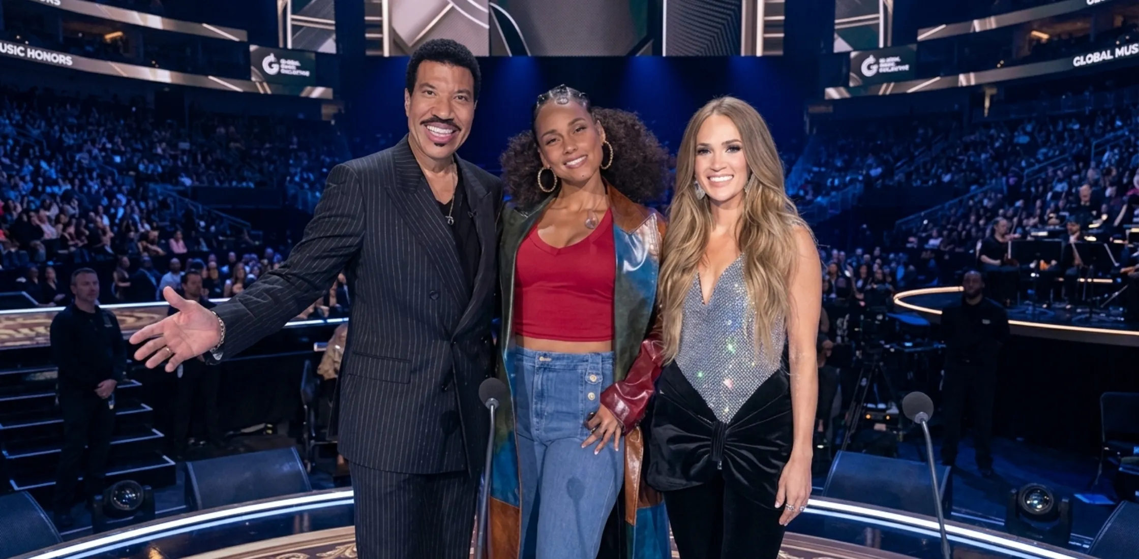 Alicia Keys wearing an ombre color block leather maxi coat during the American Idol S24 finale performance on stage.
