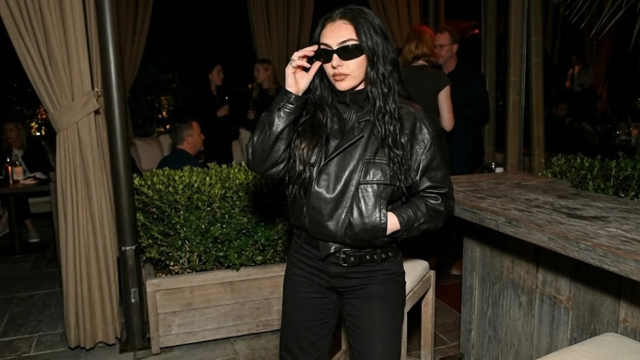 Charli XCX Marty Supreme Los Angeles Premiere oversized black leather bomber jacket with asymmetrical front and high-neck collar