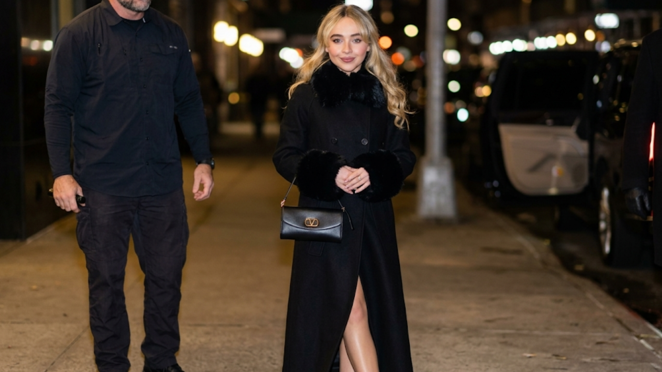 Sabrina Carpenter NYC 2026 black fur trim coat with faux-fur collar, fur cuffs, double-breasted front, and longline silhouette