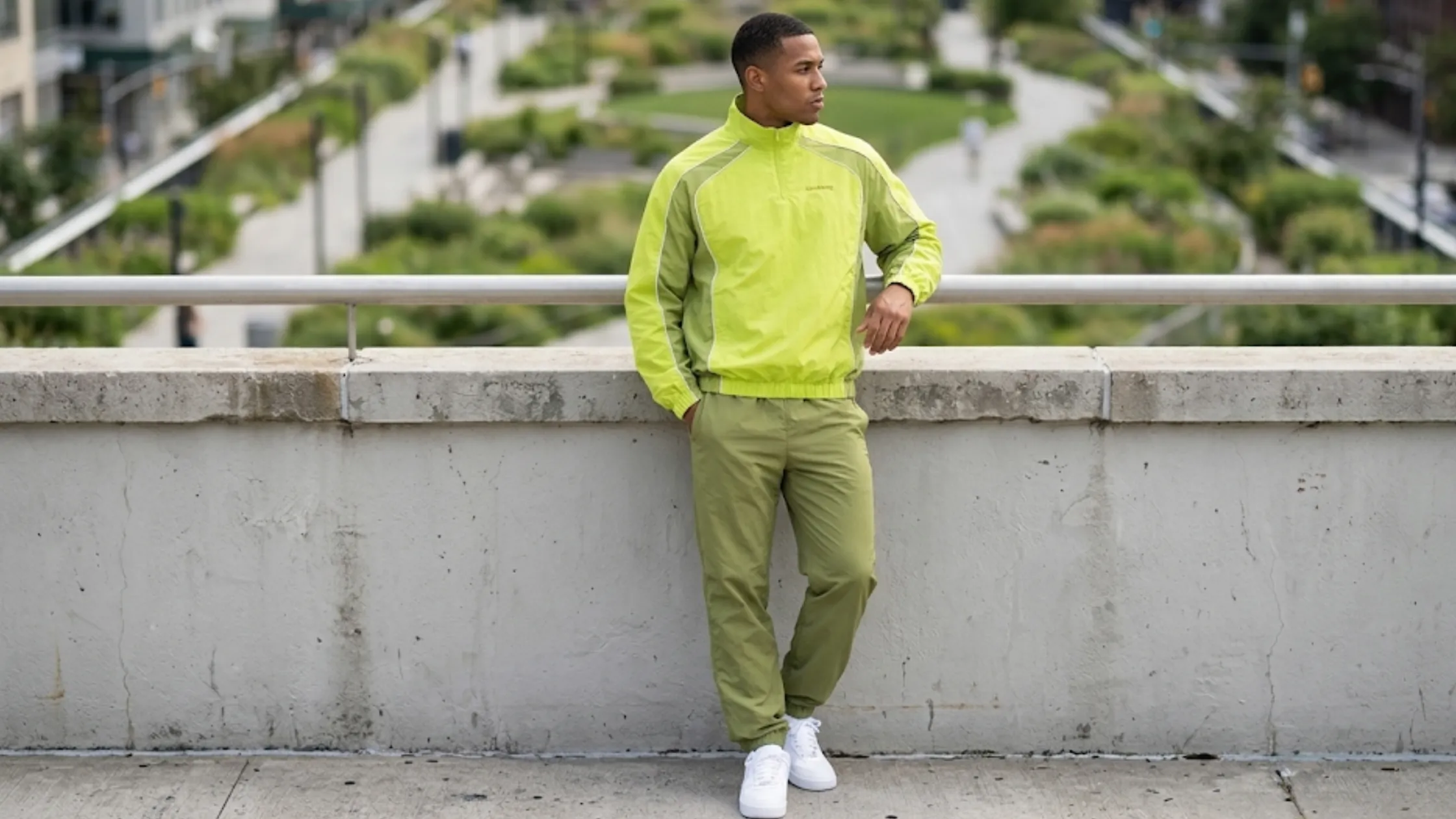Awake NY quarter zip track jacket in black, green, and blue featuring athletic paneling, white piping, stand collar, and lightweight construction