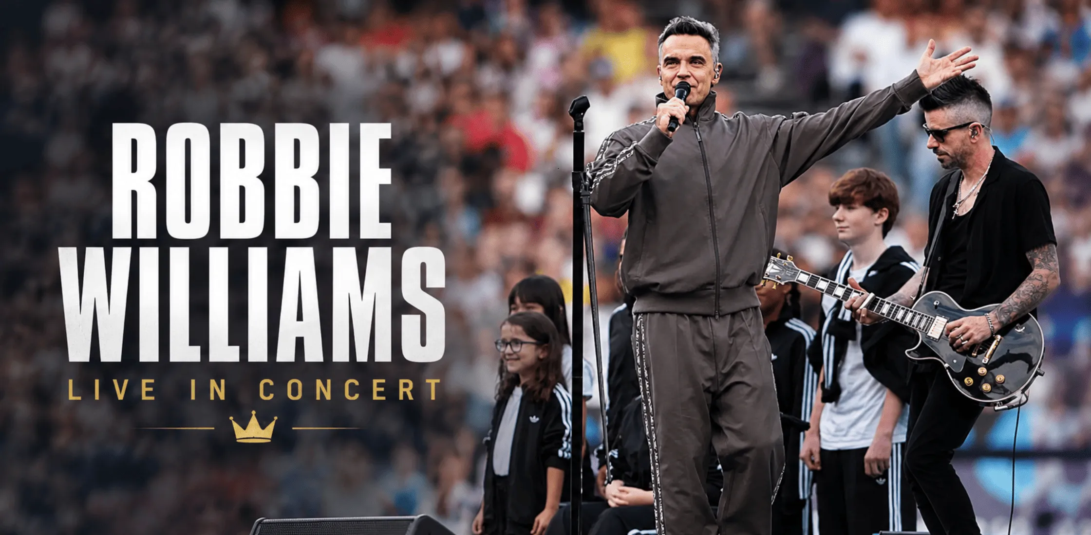 Robbie Williams Soccer Aid 2026 brown tracksuit with geometric side tape, funnel collar jacket, and matching relaxed-fit trousers