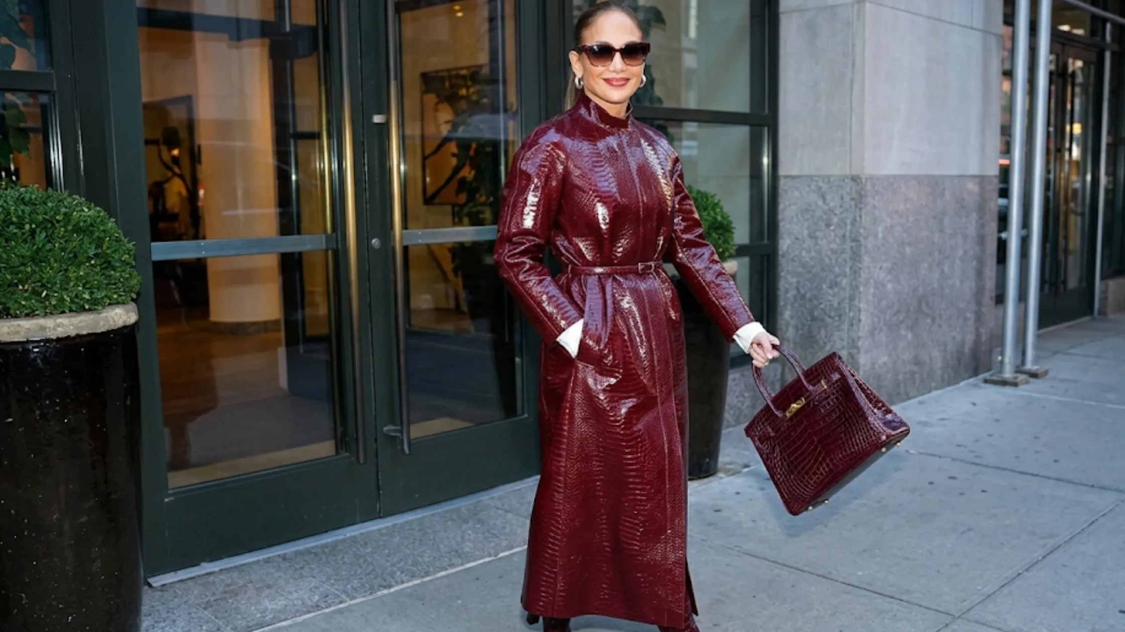 Jennifer Lopez NYC 2026 burgundy croc-embossed trench coat with ankle-length silhouette and waist belt