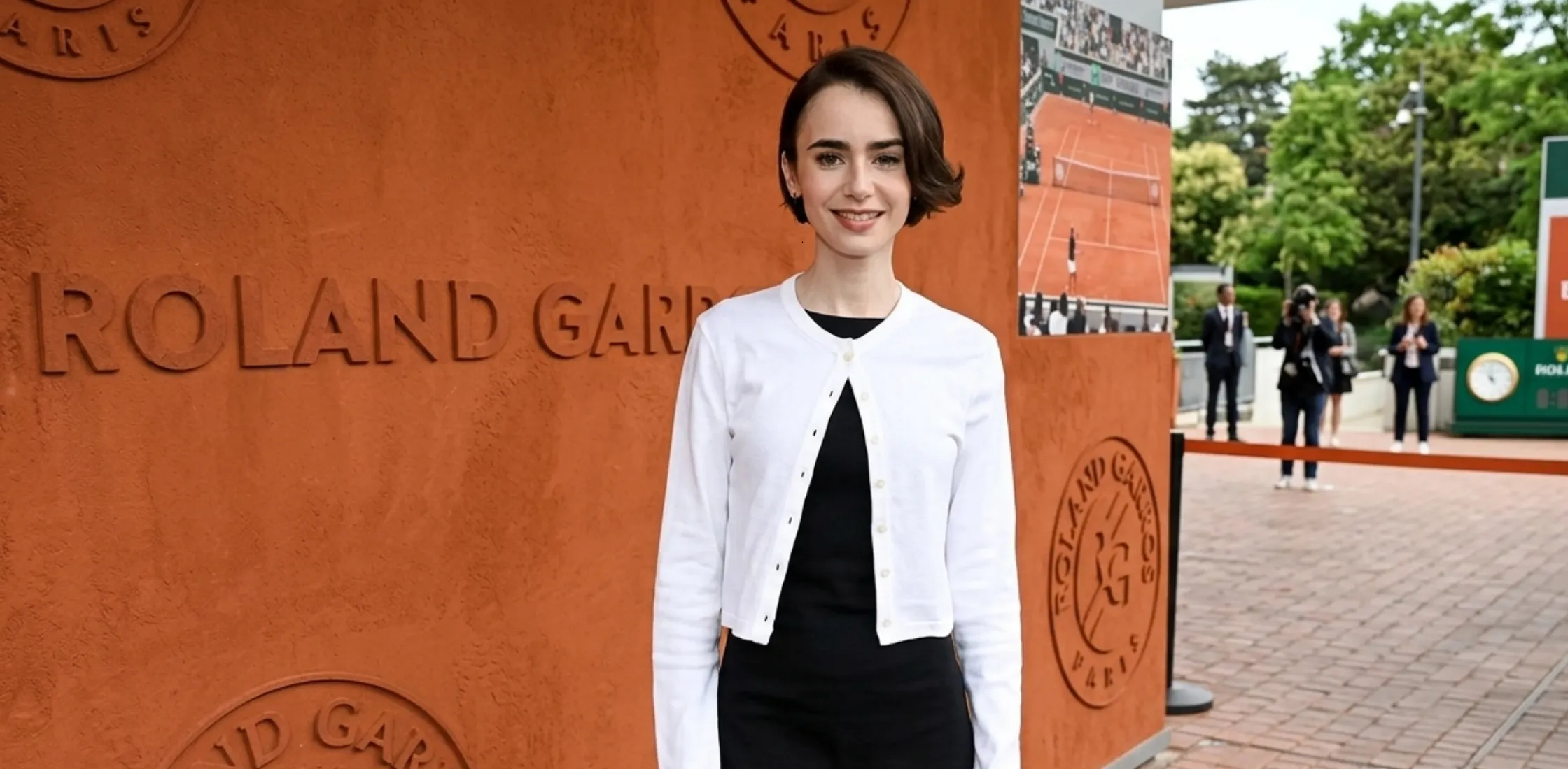 Lily Collins French Open Paris 2026 white cropped cardigan with pearl buttons and elegant Parisian-inspired styling