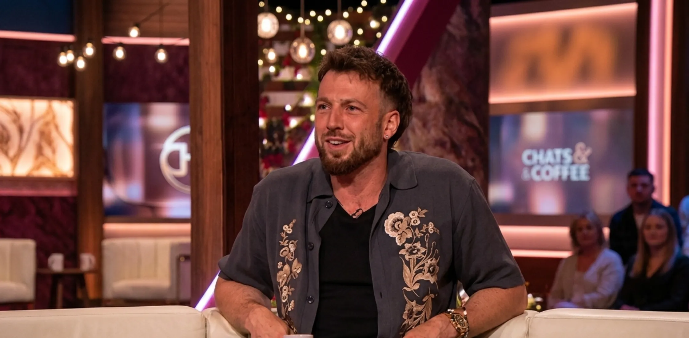 Sam Thompson wearing grey embroidered floral short-sleeve shirt from Love Island UK Aftersun Season 12 styled for bold summer fashion