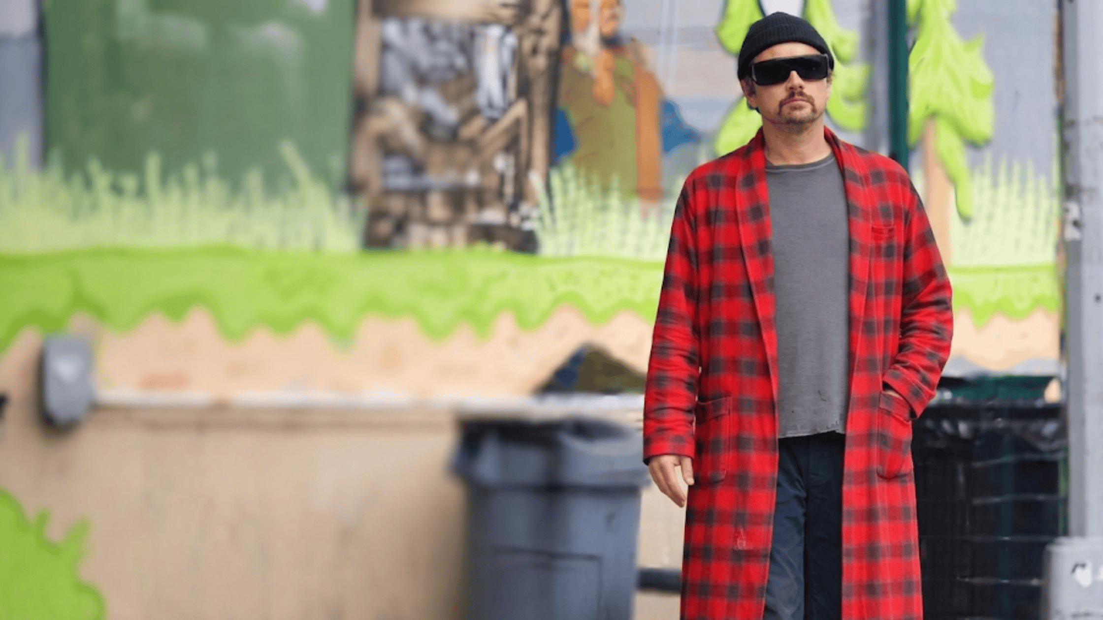 Leonardo DiCaprio as Bob Ferguson wearing a red and grey plaid flannel overcoat with a shawl collar.