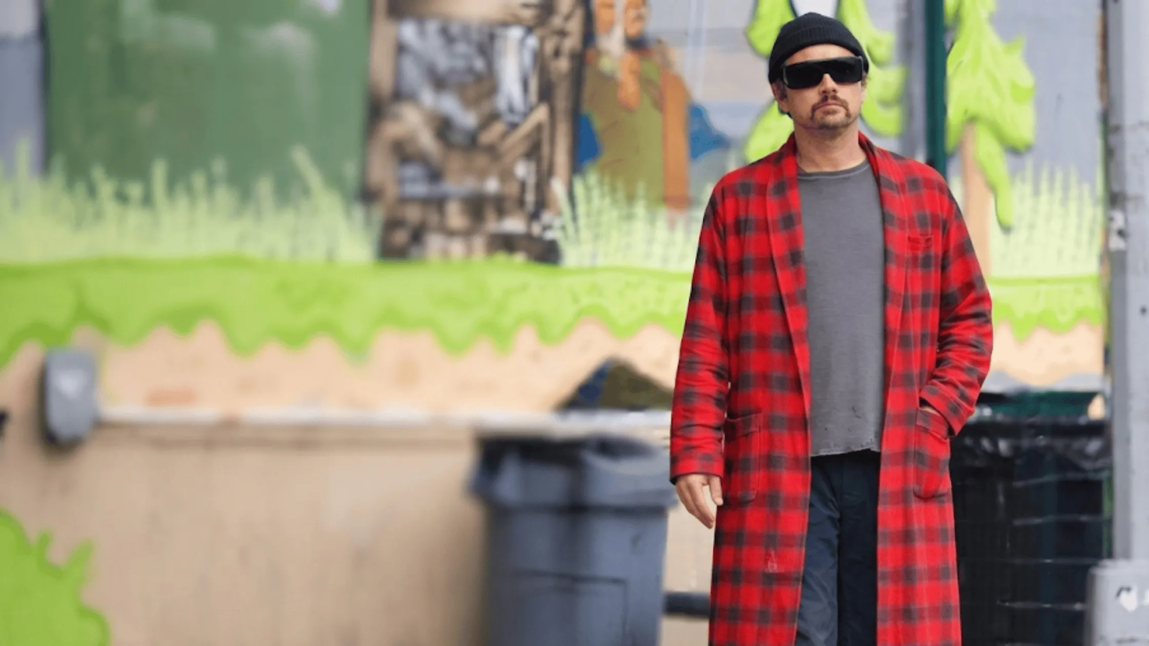 Leonardo DiCaprio as Bob Ferguson wearing a red and grey plaid flannel overcoat with a shawl collar.