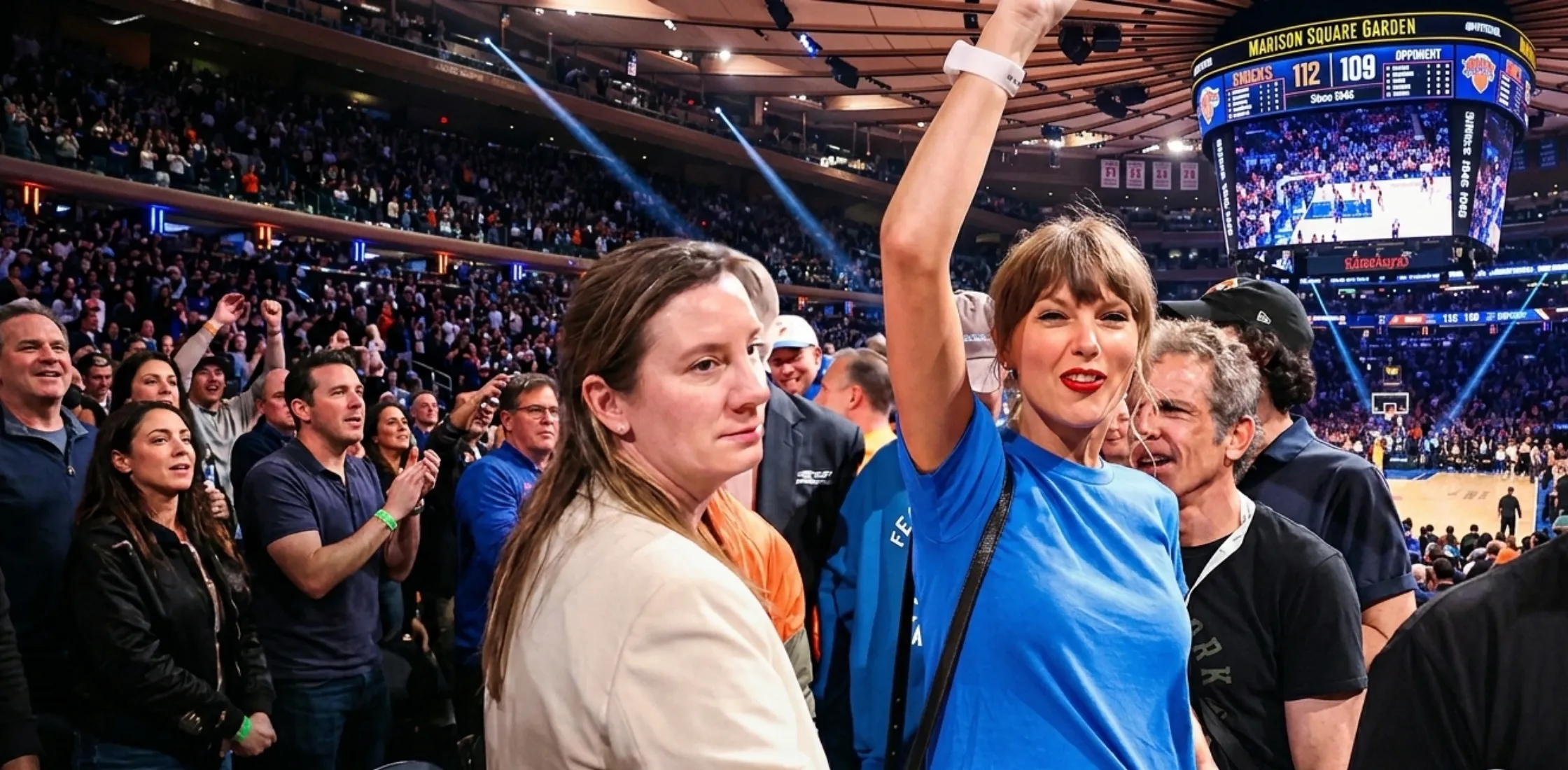 Taylor Swift wearing a royal blue cropped baby tee at Game 4 of the 2026 NBA Finals courtside, styled with dark denim and minimal accessories inside Madison Square Garden.