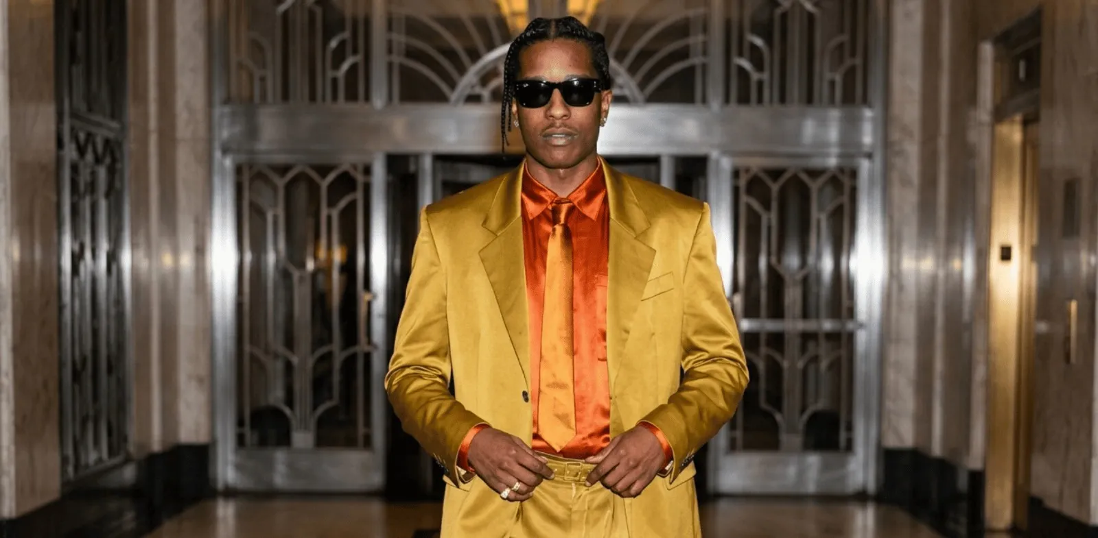 A$AP Rocky Financial District NYC 2026 metallic gold suit with satin blazer, pleated trousers, and luxury streetwear styling