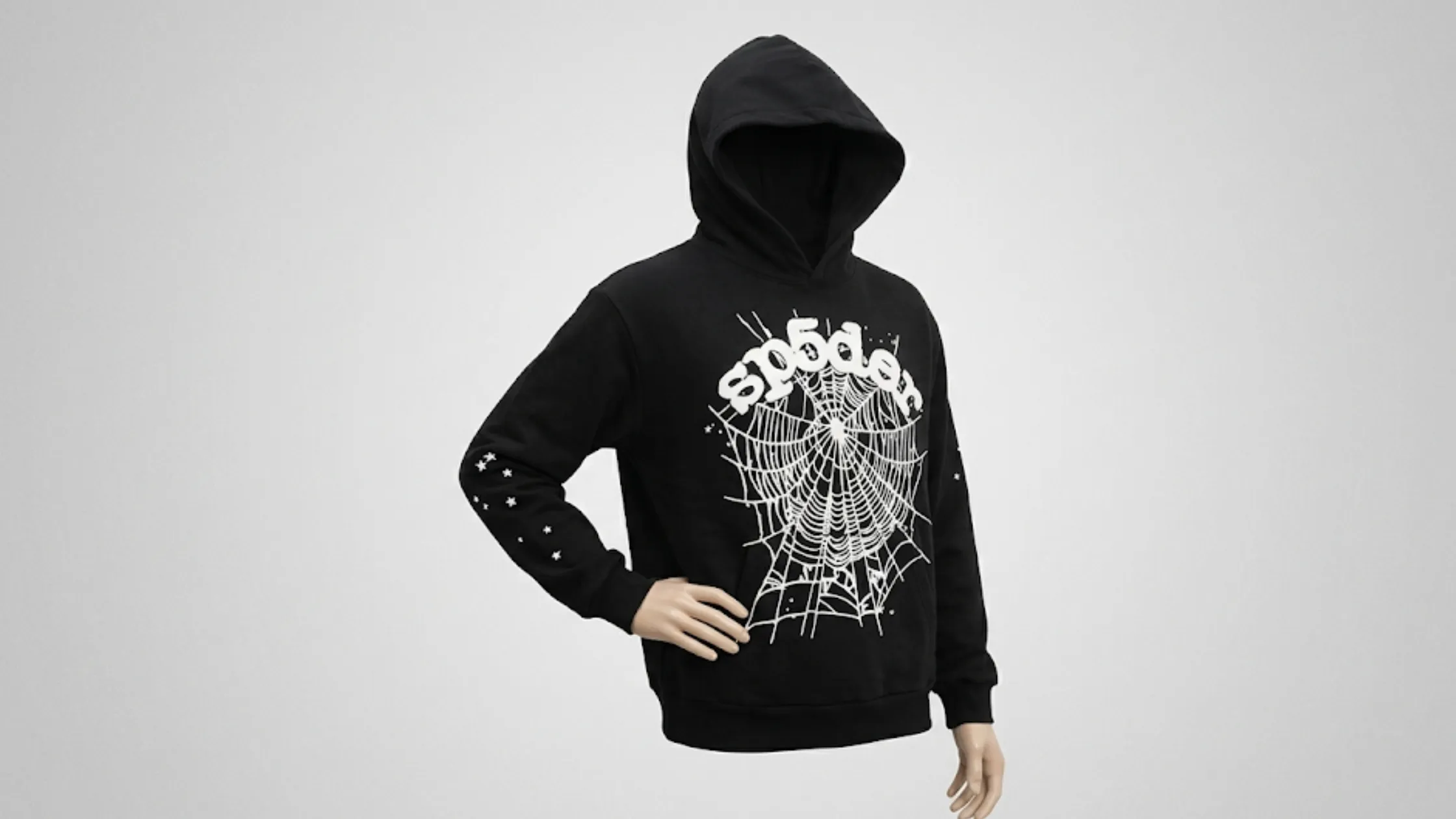 Black and White Sp5der hoodie with oversized spiderweb graphic, puff-print logo, and star motif sleeves on a black pullover design