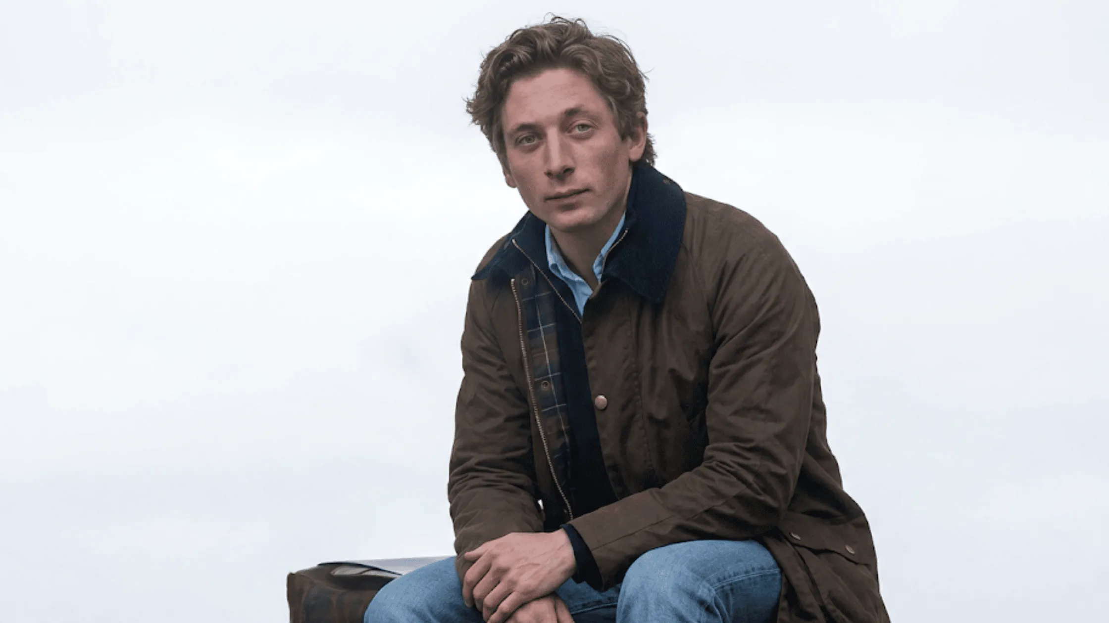 Jeremy Allen White Social Reckoning brown utility cotton canvas field jacket with a dark corduroy collar.