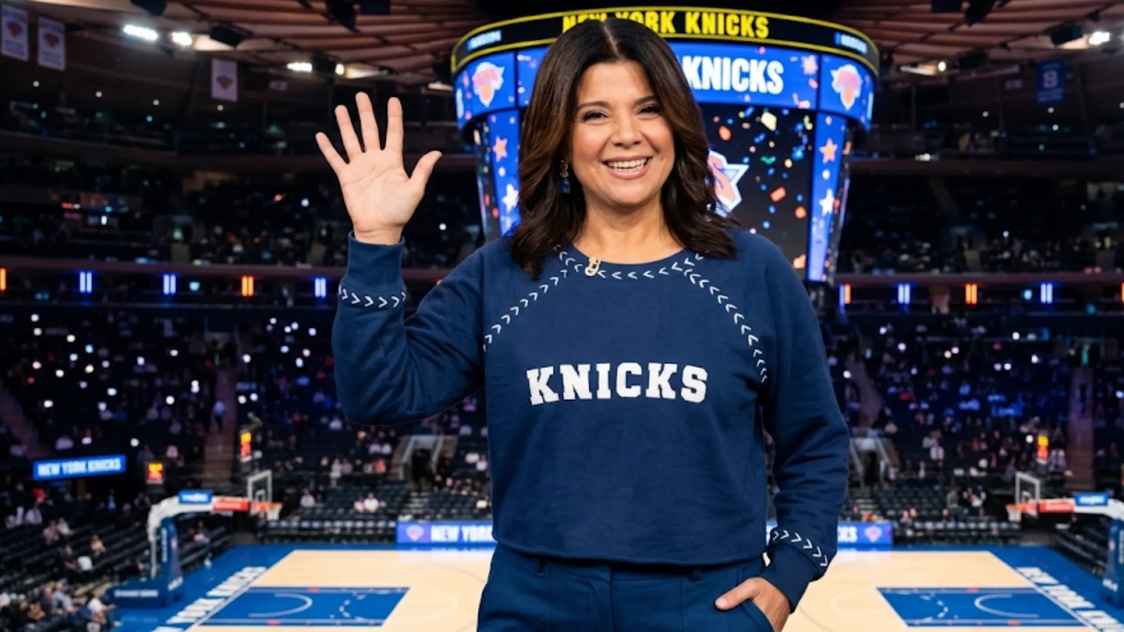 The View Ana Navarro Blue Knicks Sweater featuring white chenille KNICKS lettering, cropped silhouette, raglan sleeves, and slate blue knit fabric.