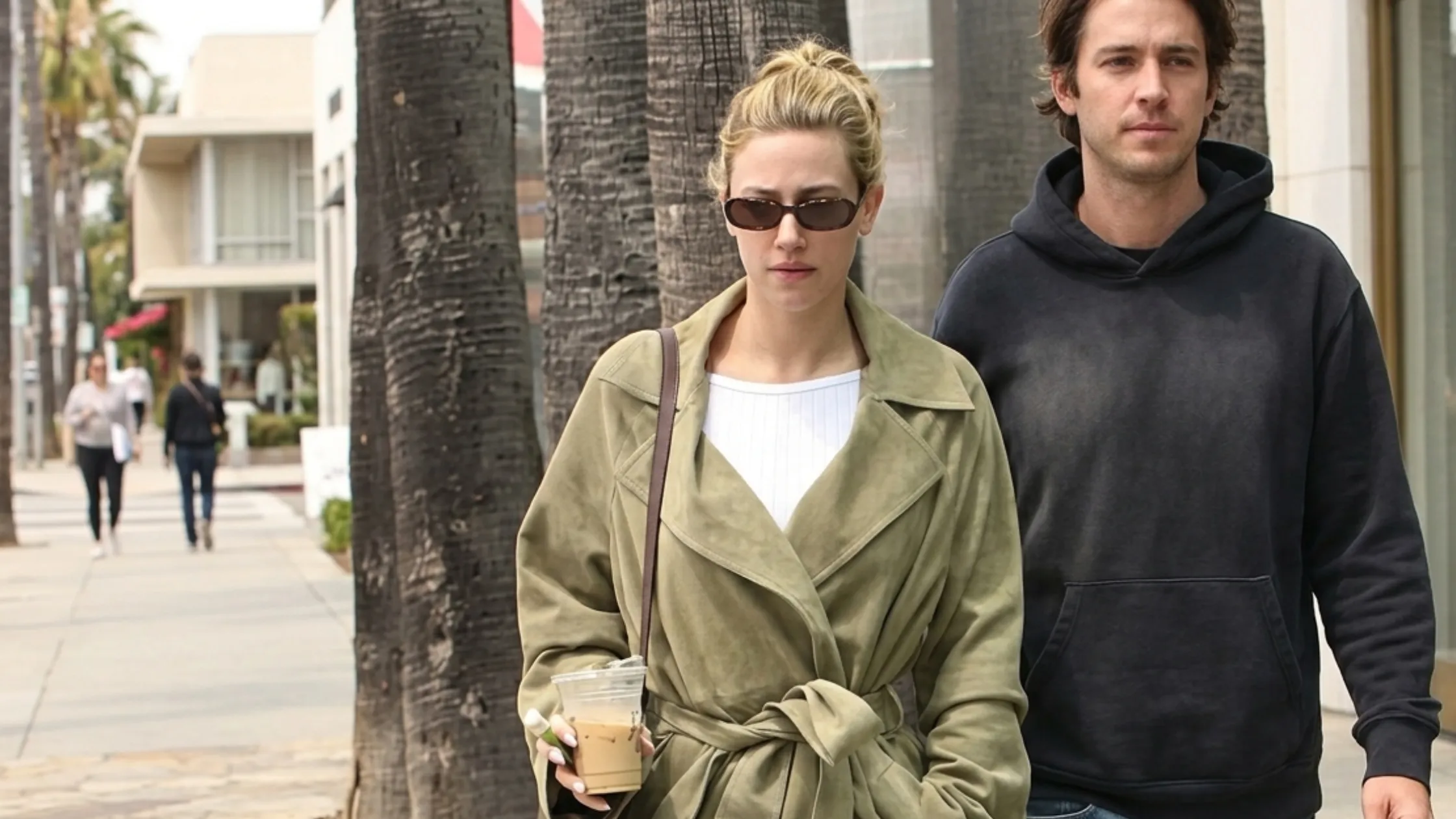 Lili Reinhart wearing a 2026 olive green suede oversized trench coat in Los Angeles street style, belted longline silhouette with minimalist luxury aesthetic