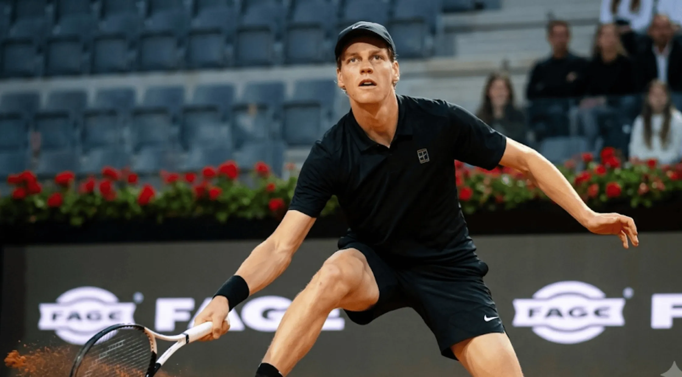 Jannik Sinner wearing the black NikeCourt polo shirt featuring a structured collar, short sleeves, and the white geometric tennis emblem on the left chest.
