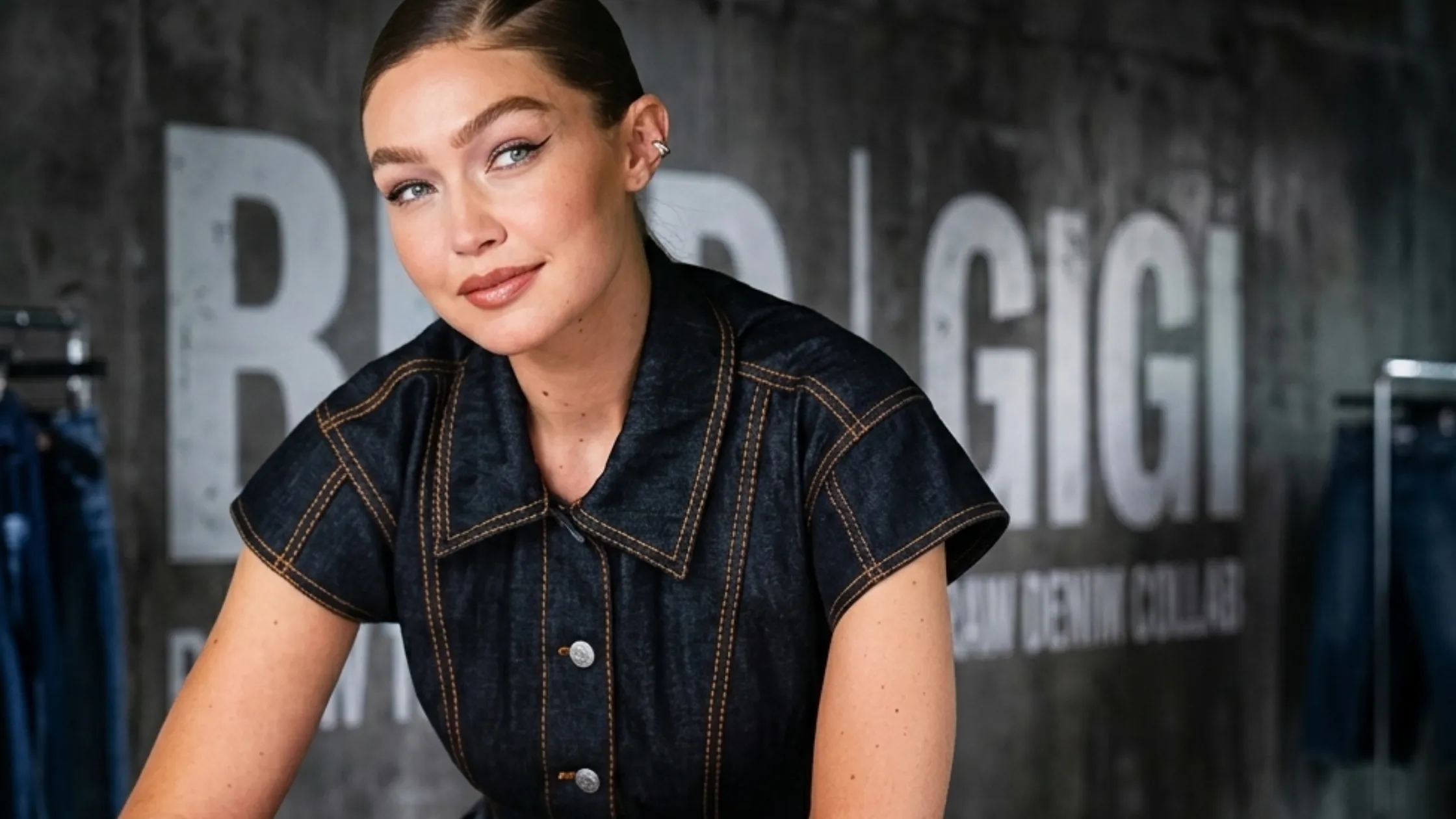 Gigi Hadid Maybelline NYC Soho dark denim jumpsuit look with structured tailoring and bold copper stitching