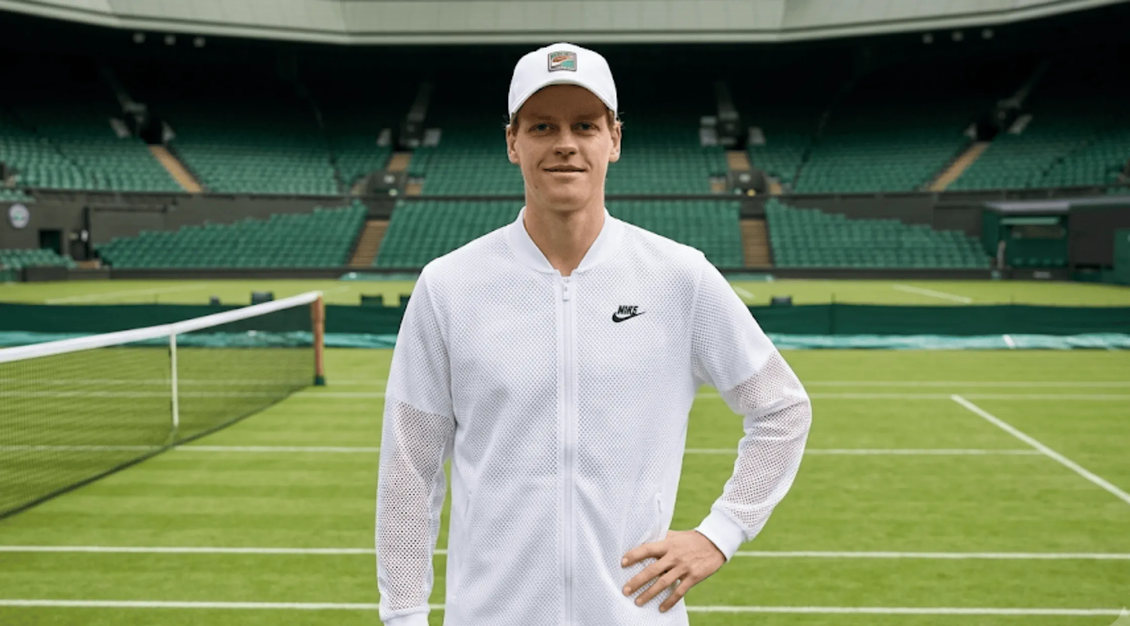 Jannik Sinner wearing the white engineered mesh full-zip performance tennis jacket with a honeycomb perforated texture on the court at Wimbledon 2026.