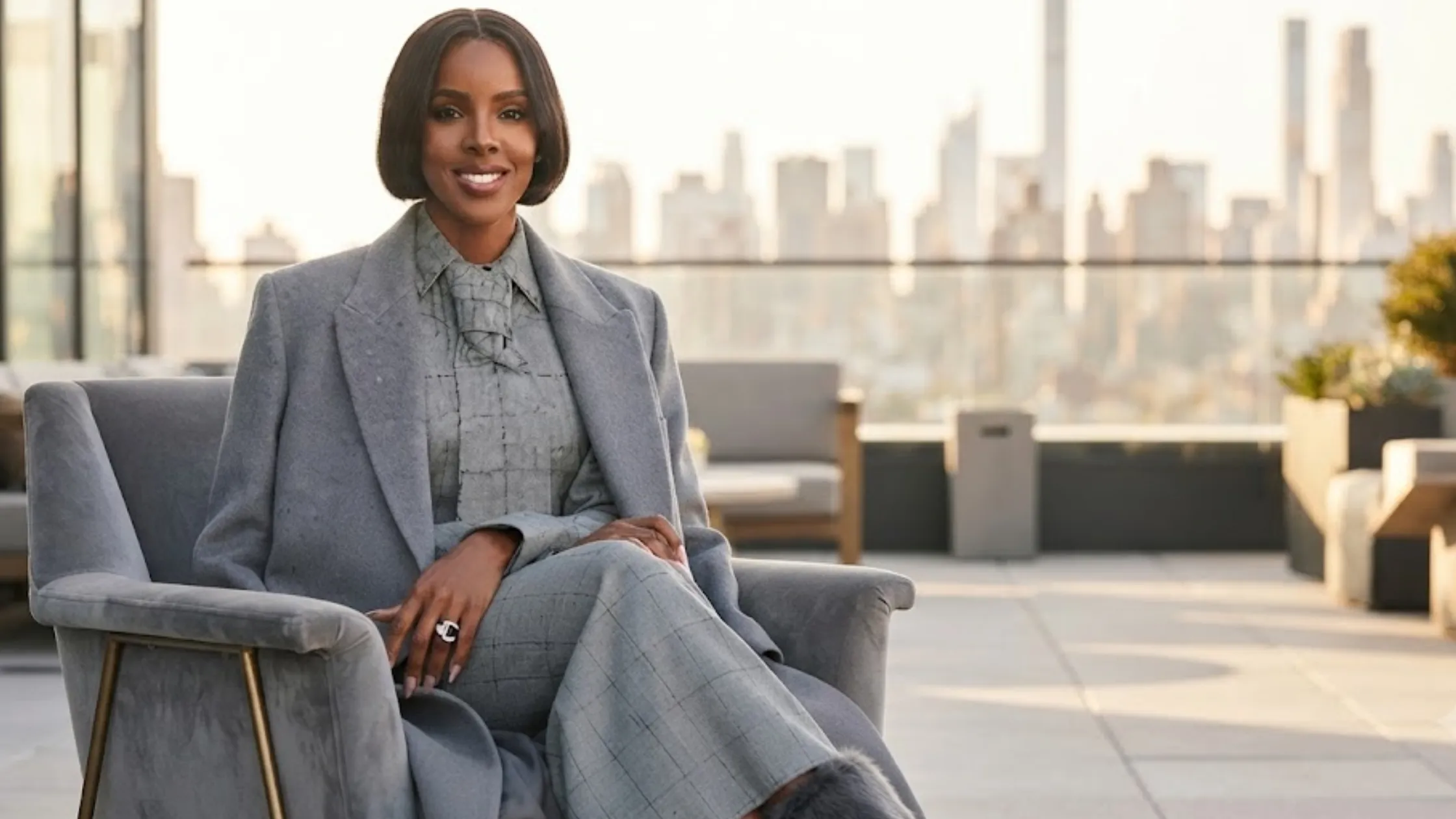 Kelly Rowland NYC oversized gray wool-blend maxi coat with notched lapels, padded shoulders, and elegant longline silhouette