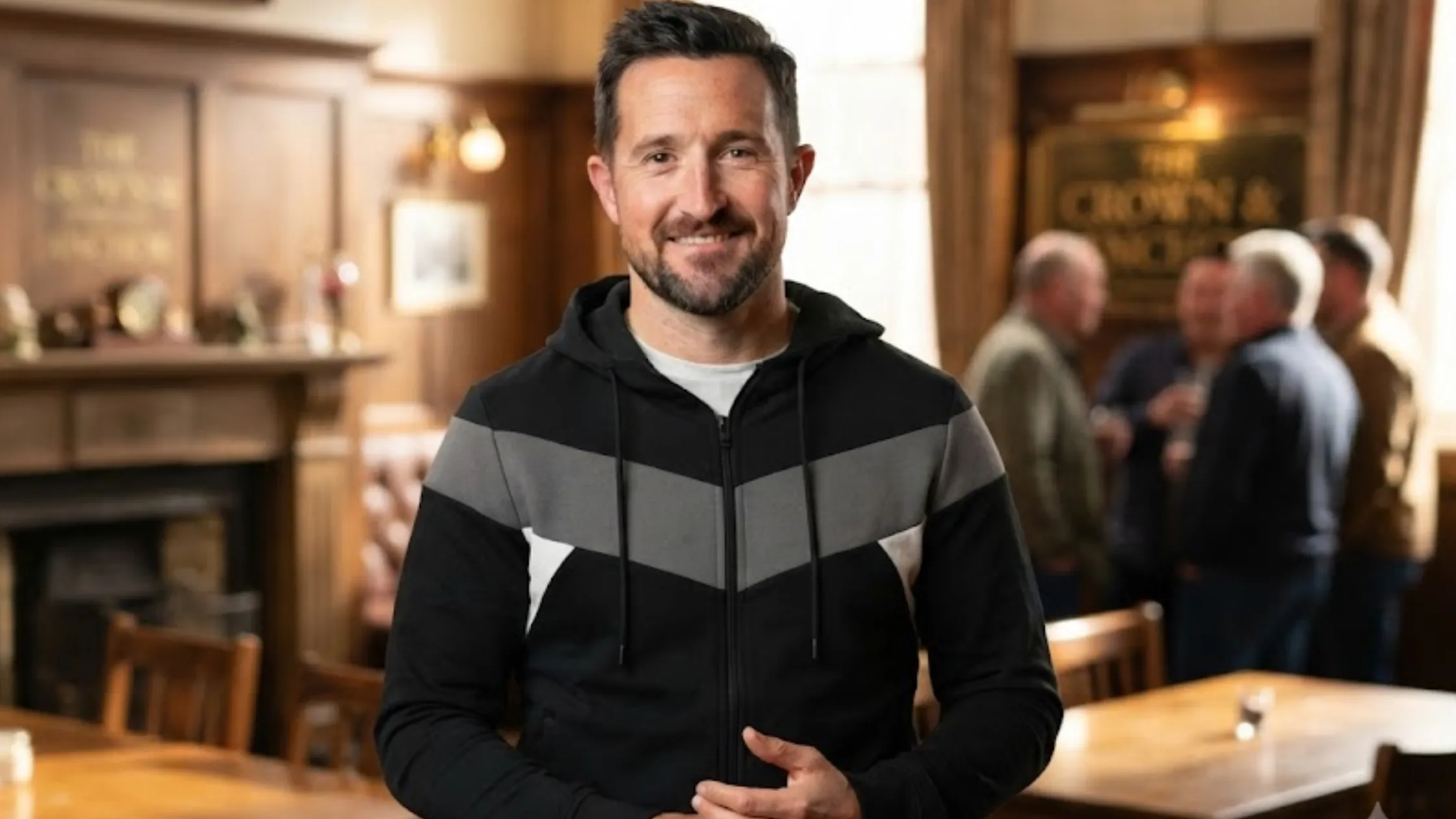 Emmerdale August 2025 LUKE 1977 Black Baldur Zip-Up Hoodie with Grey Chevron Panel