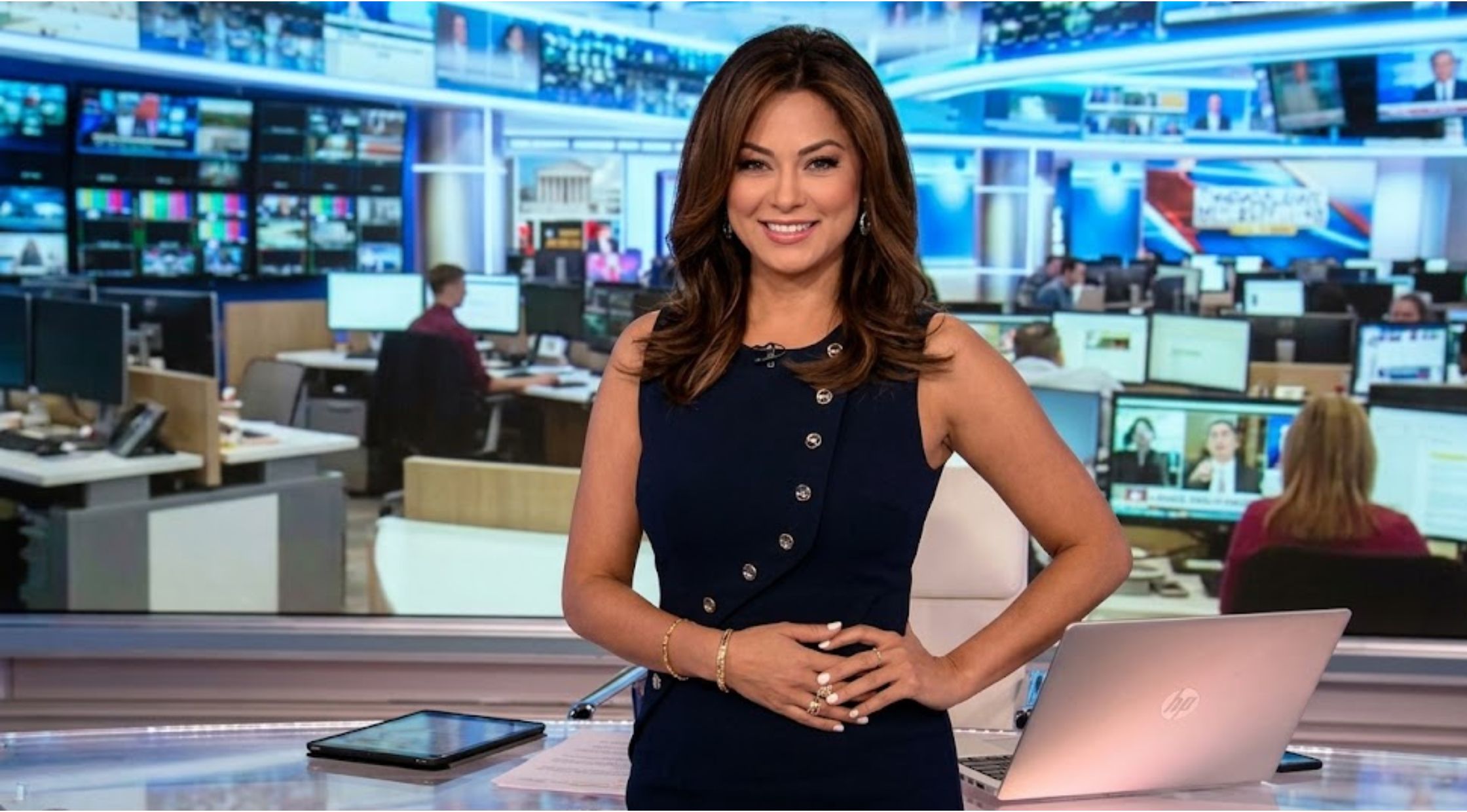 Why Aishah Hasnie’s Navy Asymmetric Button Knit Top on America’s Newsroom is a Modern Workwear Staple