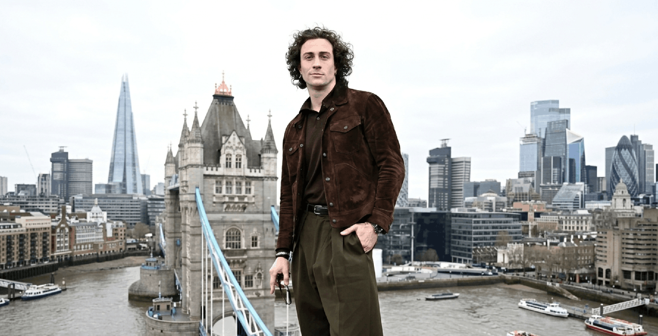 Aaron Taylor-Johnson wearing Fuze suede trucker jacket at London photocall, dark tobacco brown geometric seam menswear design