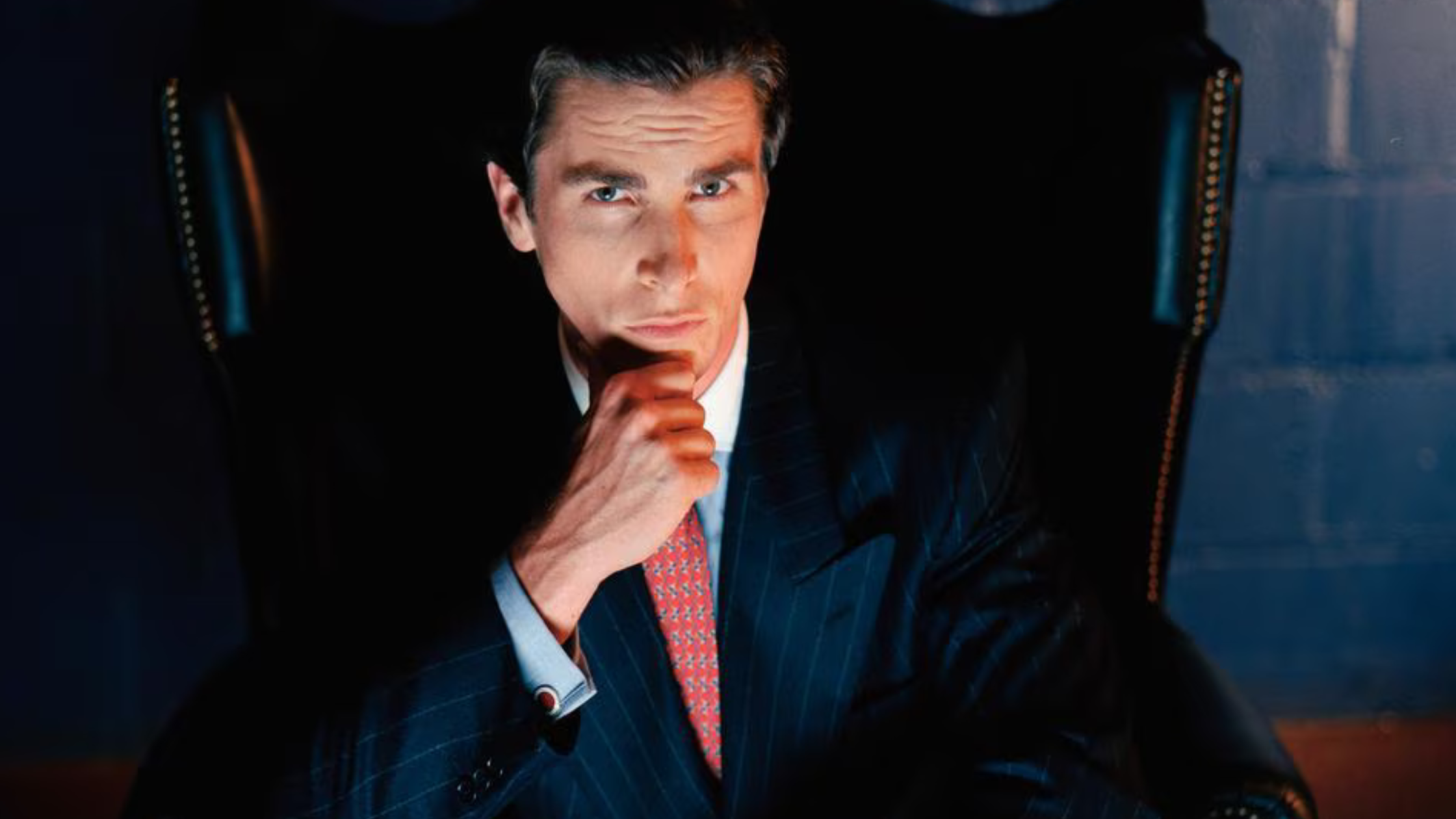 American Psycho character Patrick Bateman wearing a structured black overcoat showcasing 1980s Wall Street power fashion