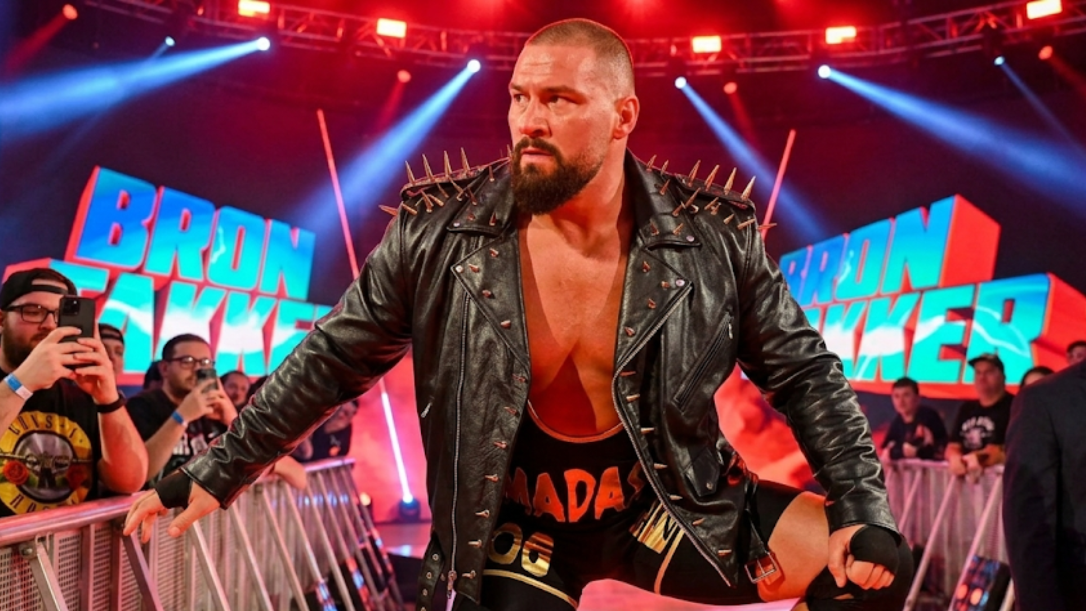 Bron Breakker WWE Survivor Series black asymmetrical biker leather jacket with silver spike epaulets and belted waist design