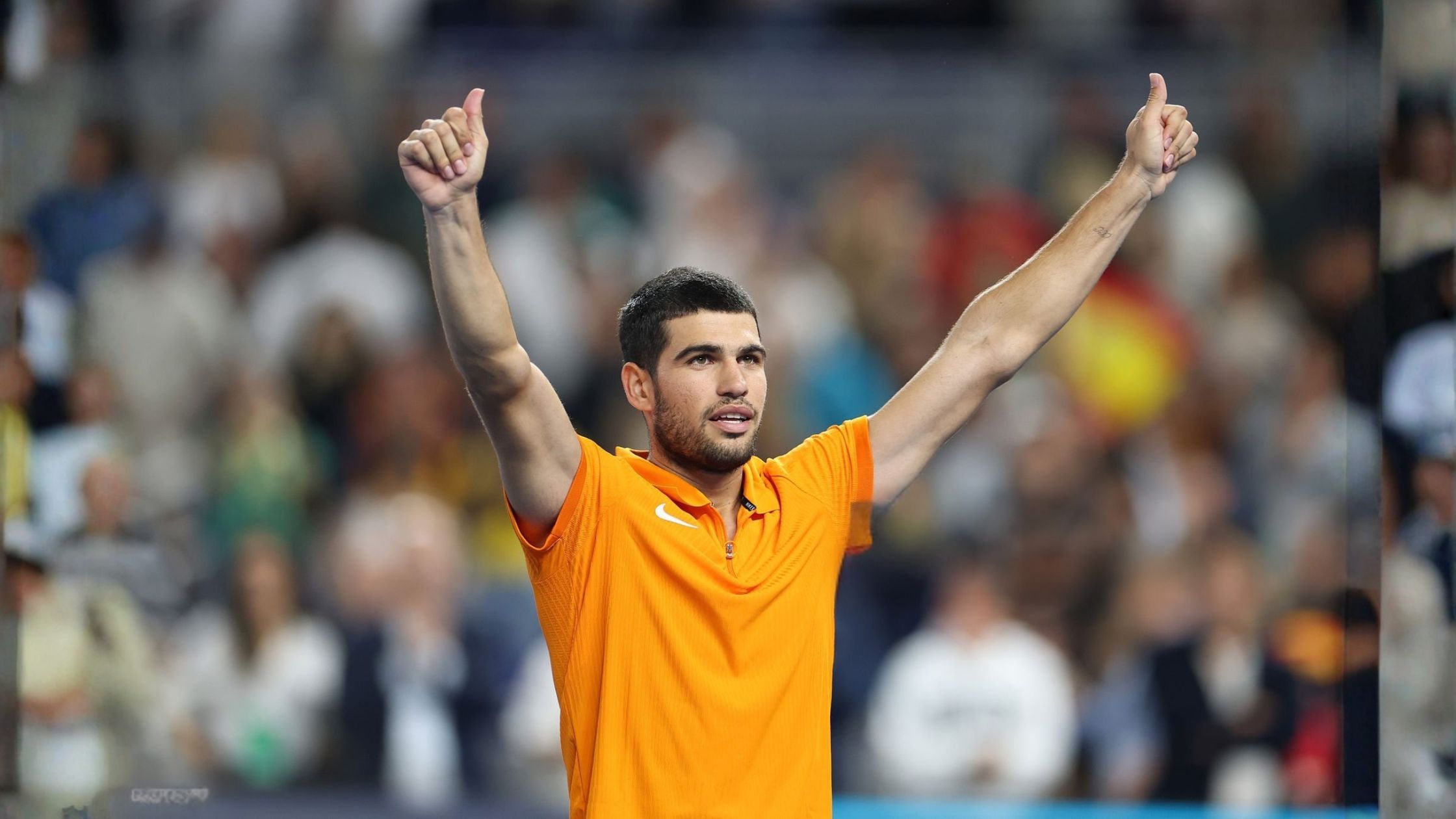 Carlos Alcaraz wearing bright orange Nike short-sleeve shirt at Miami Invitational 2025 tennis match