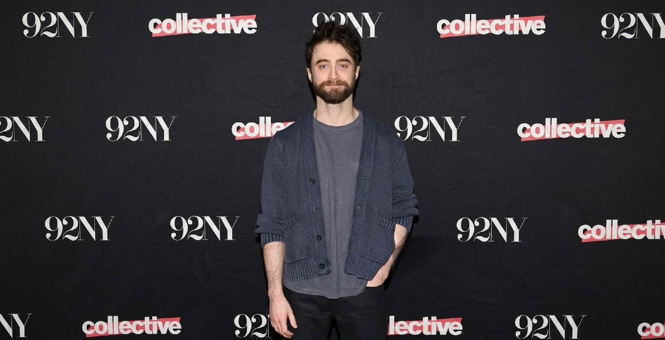 Daniel Radcliffe wearing slate grey shawl collar cardigan at 92NY 2026 event