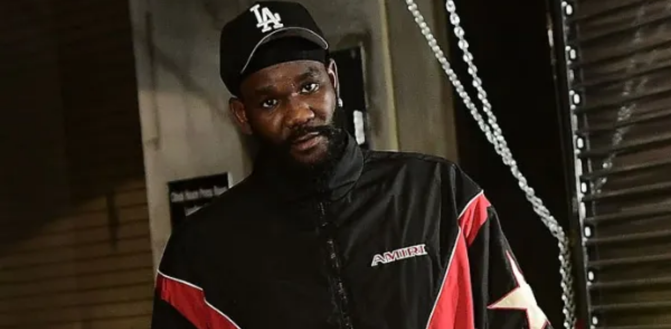 Deandre Ayton Brooklyn Nets vs Los Angeles Lakers black track jacket with red and white geometric panels, AMIRI logo, and star patch sleeve design