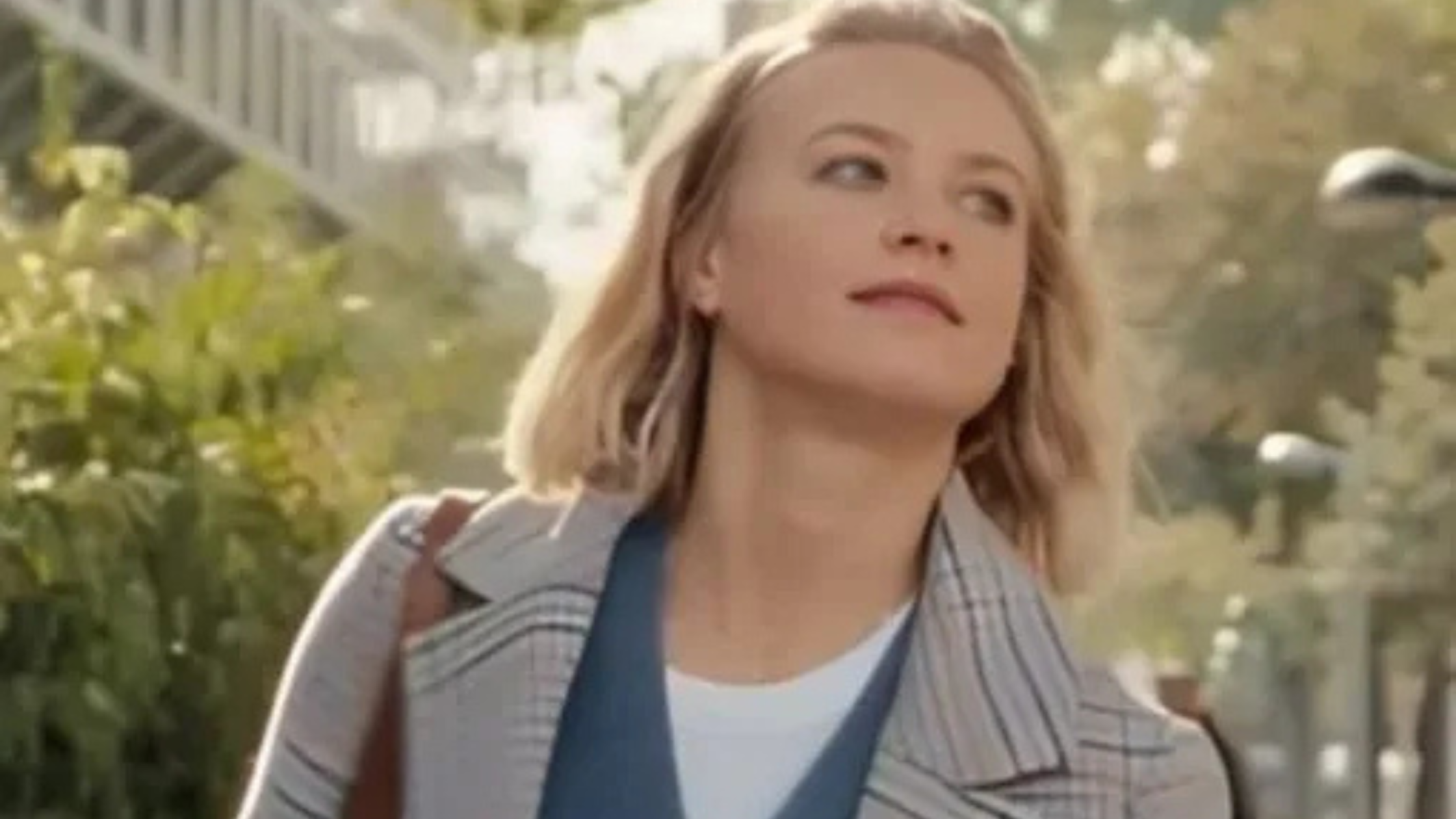 Jeanne Goursaud wearing a grey and blue plaid longline coat with notched lapels as Sara Wulf in Exterritorial 2025 movie style.