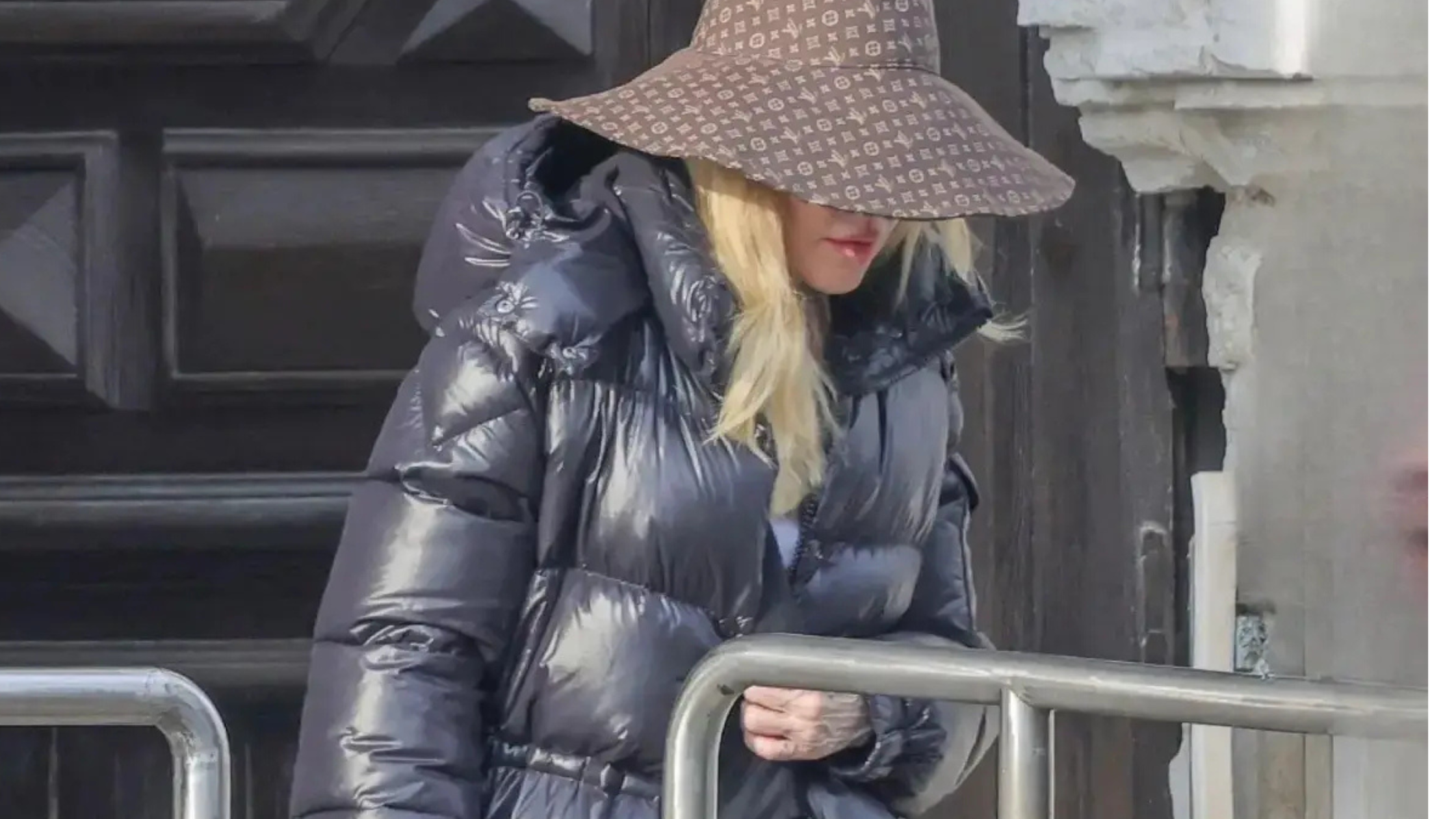 Madonna wears a stylish high-gloss black puffer coat, oversized and luxurious, on set in Venice, Italy.