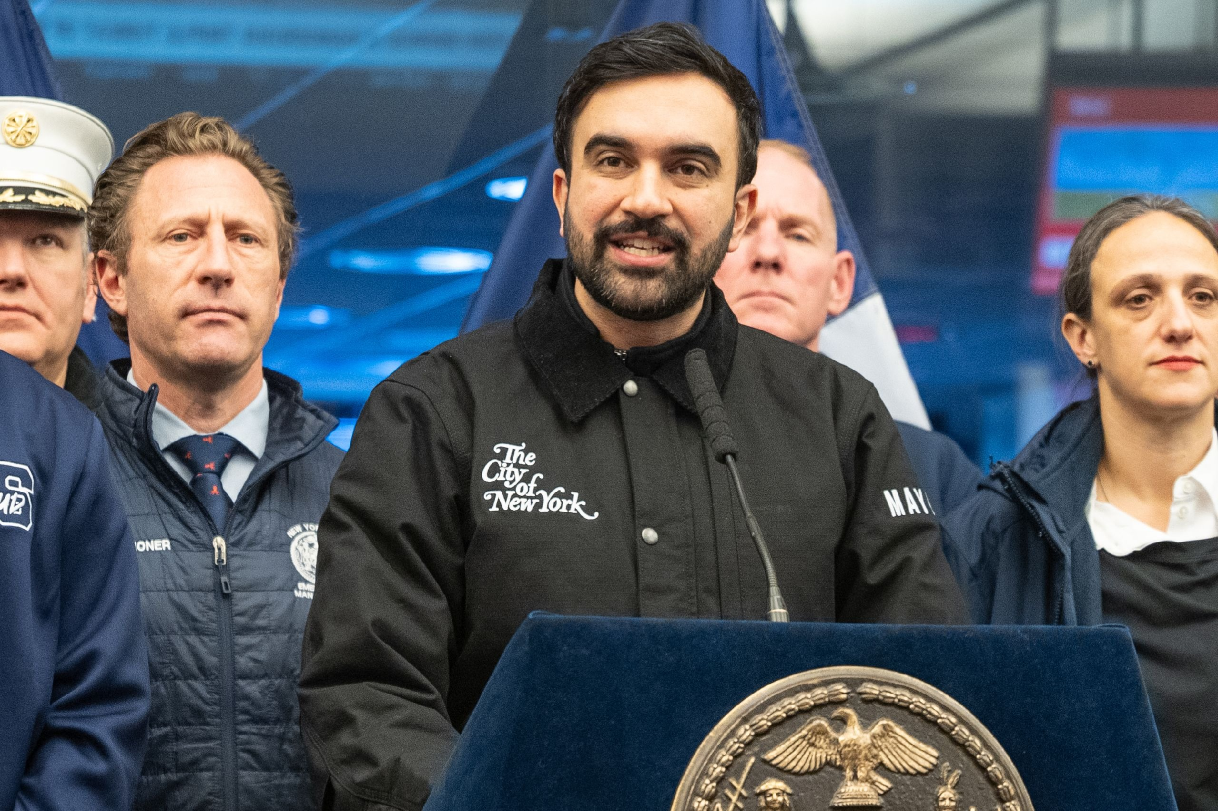 Mayor Zohran Mamdani wearing The City of New York Embroidery Black Carhartt Detroit Trucker Jacket with corduroy collar and silver snap buttons during public event with New York City Fire Department
