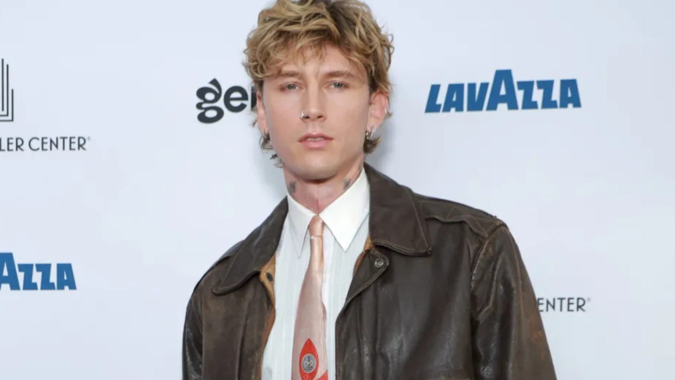 Machine Gun Kelly wearing iconic Lost Americana tour outfits, Grammy vests, and rock-inspired jackets on stage and red carpet